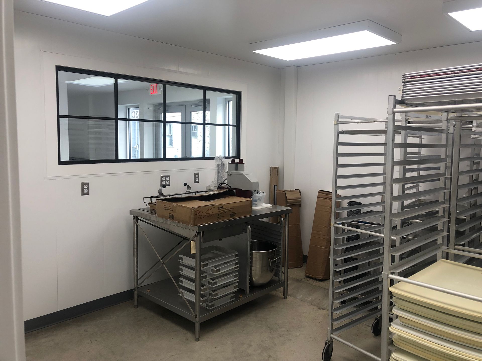 A room with a table , shelves , and a window.
