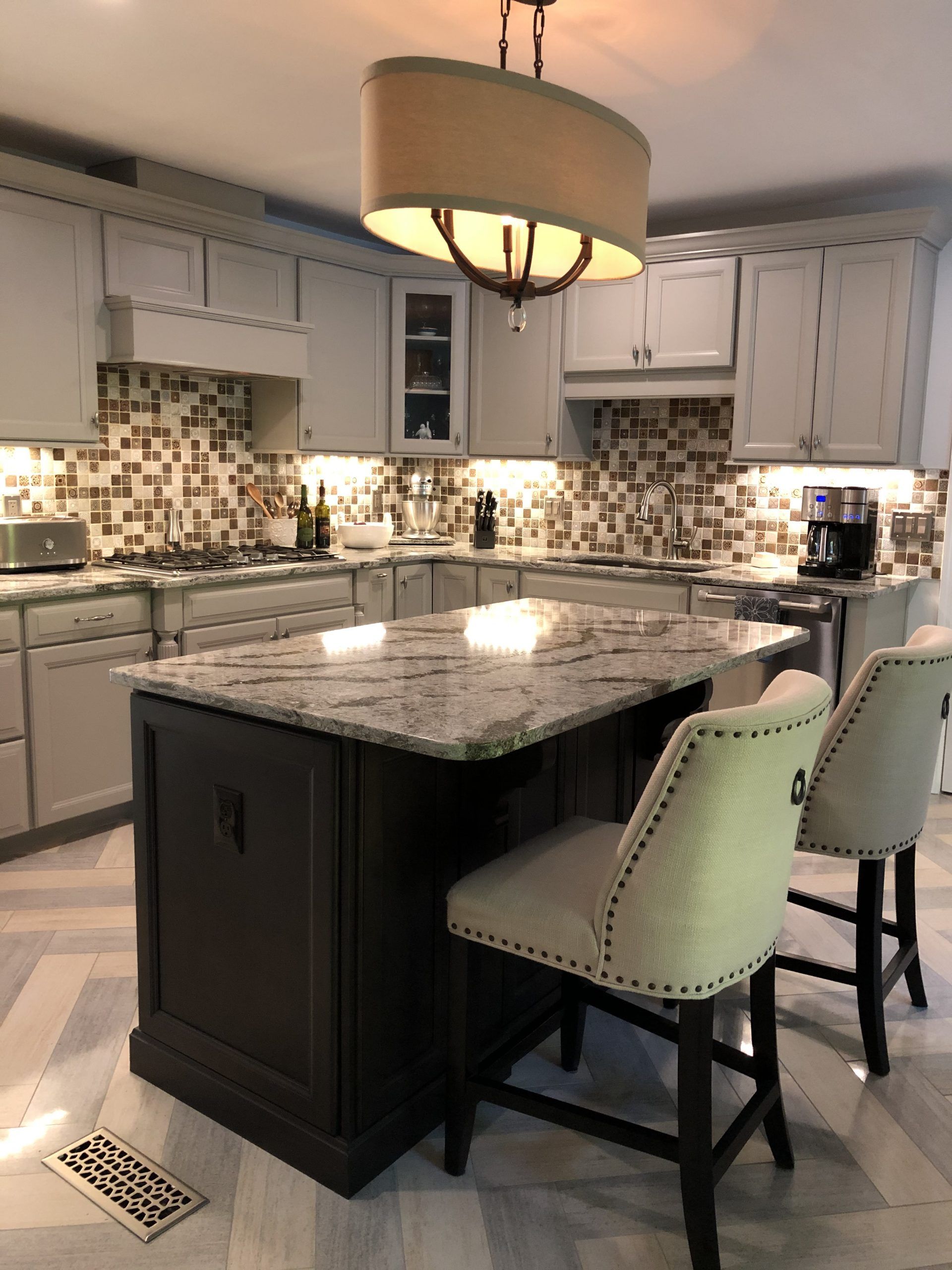 A kitchen with a large island and two chairs