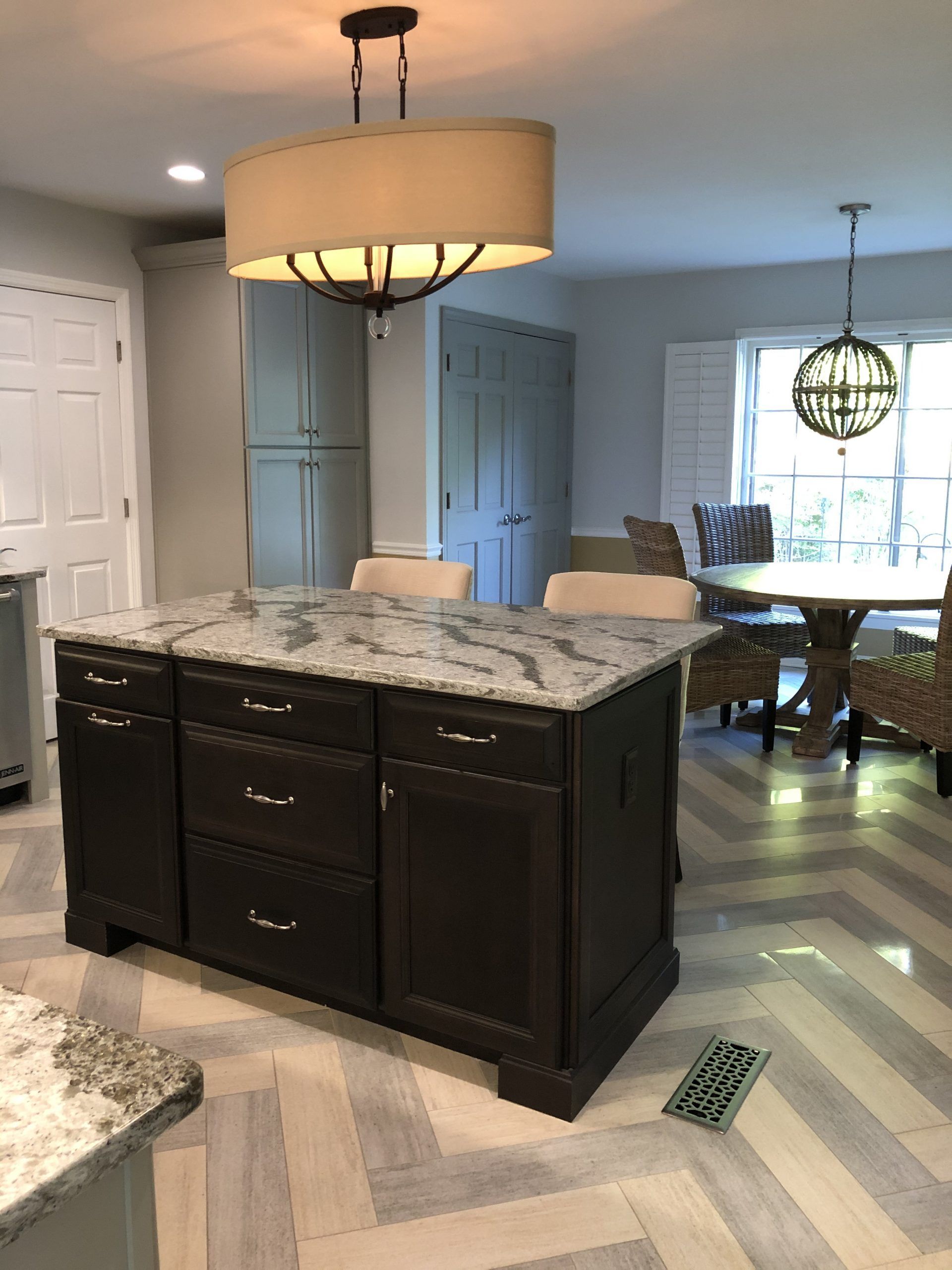 A kitchen with a large island and a chandelier hanging from the ceiling.