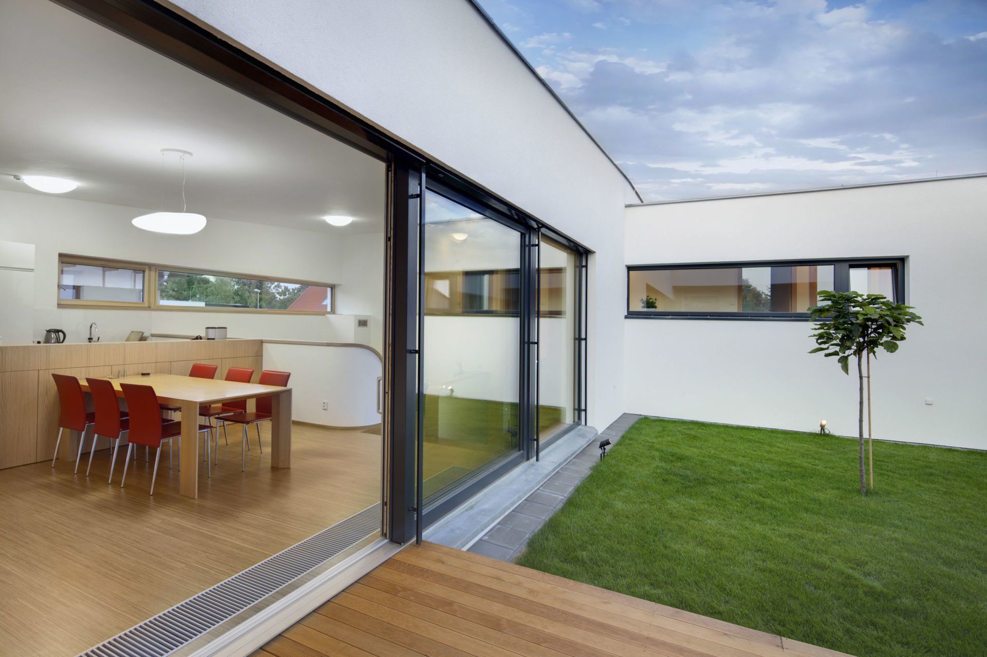 A dining room with a table and chairs and a sliding glass door leading to a courtyard.