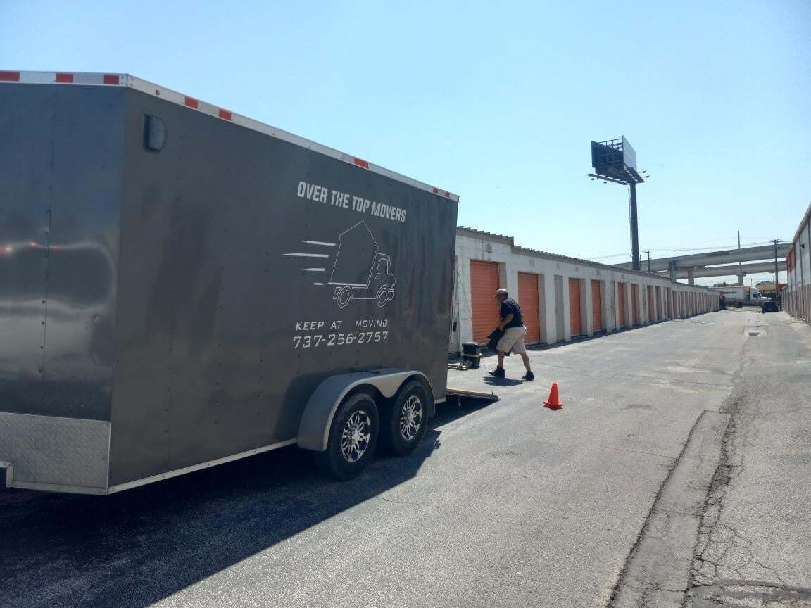 A man is pulling a trailer down a street.