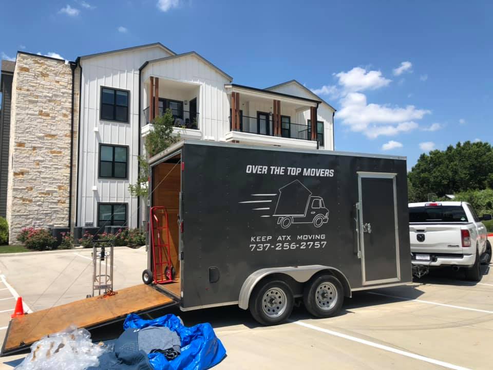 A black trailer is parked in front of a building.