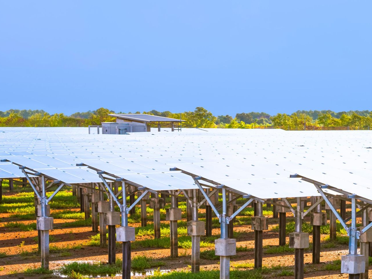 American flag waving in the wind against a cloudy blue sky, atop a silver flagpole.