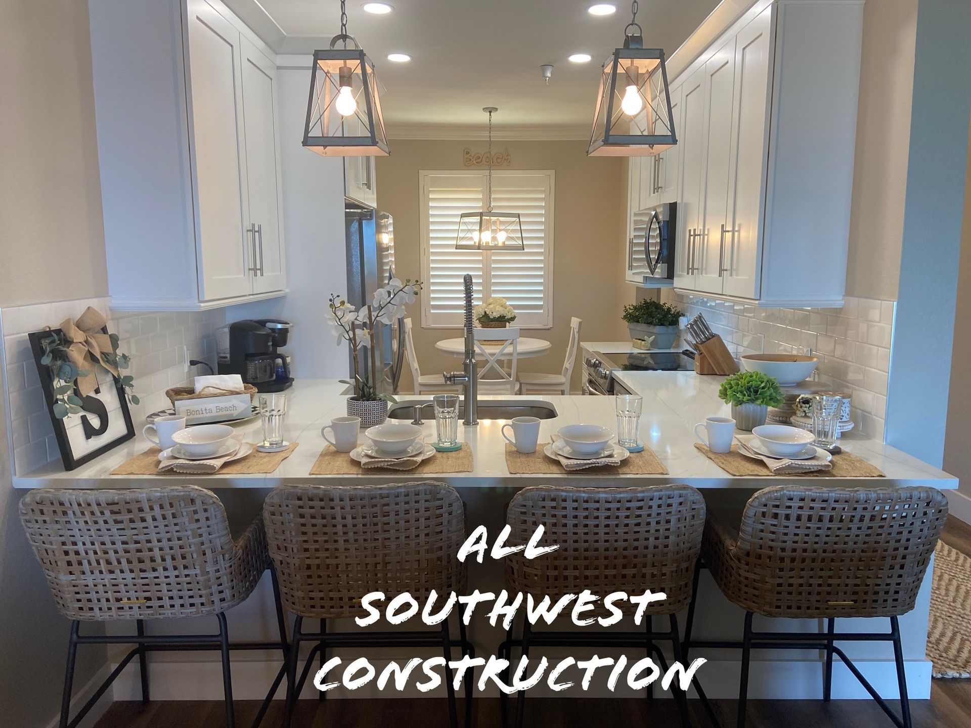 Kitchen with bar seating, white cabinets, and pendant lights. 