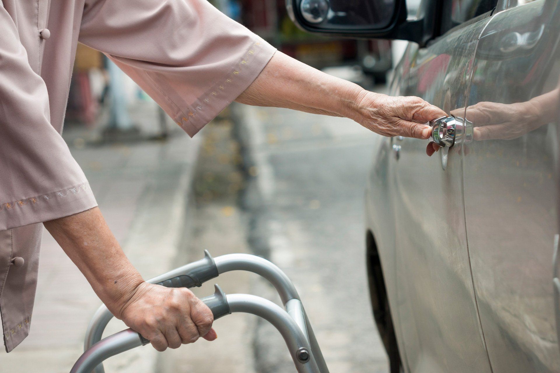 Elderly Transportation — Senior Woman Open Car Door With Walker On Street in Marco Island, FL