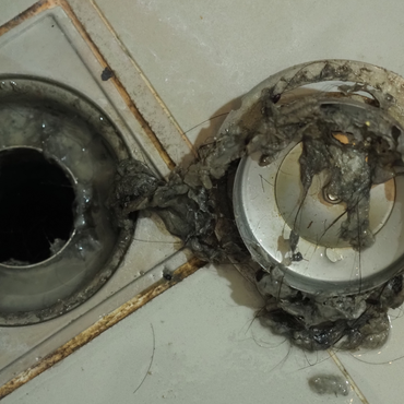 A person is fixing a pipe with a wrench.