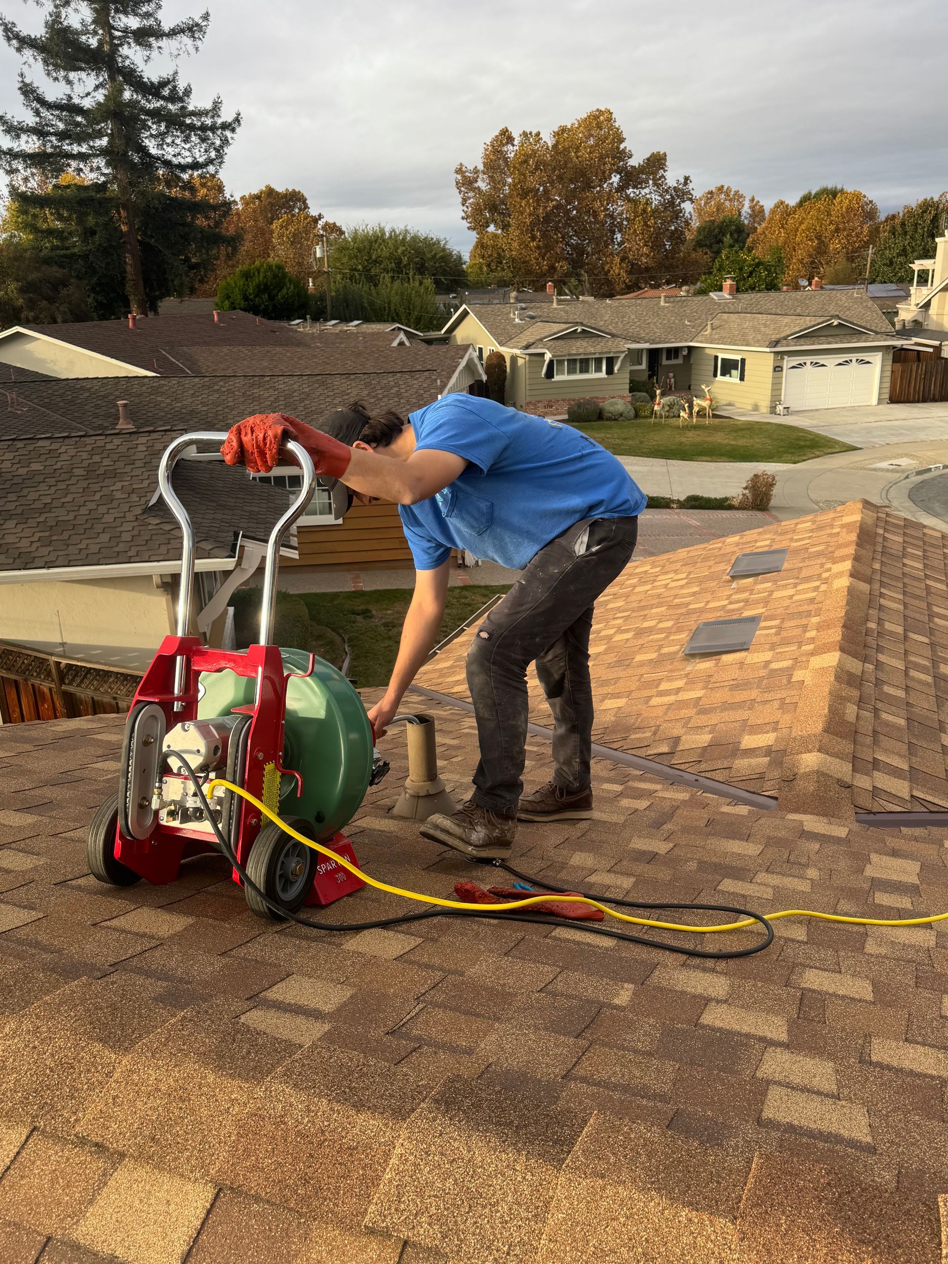 A man is working on a roof with a machine.