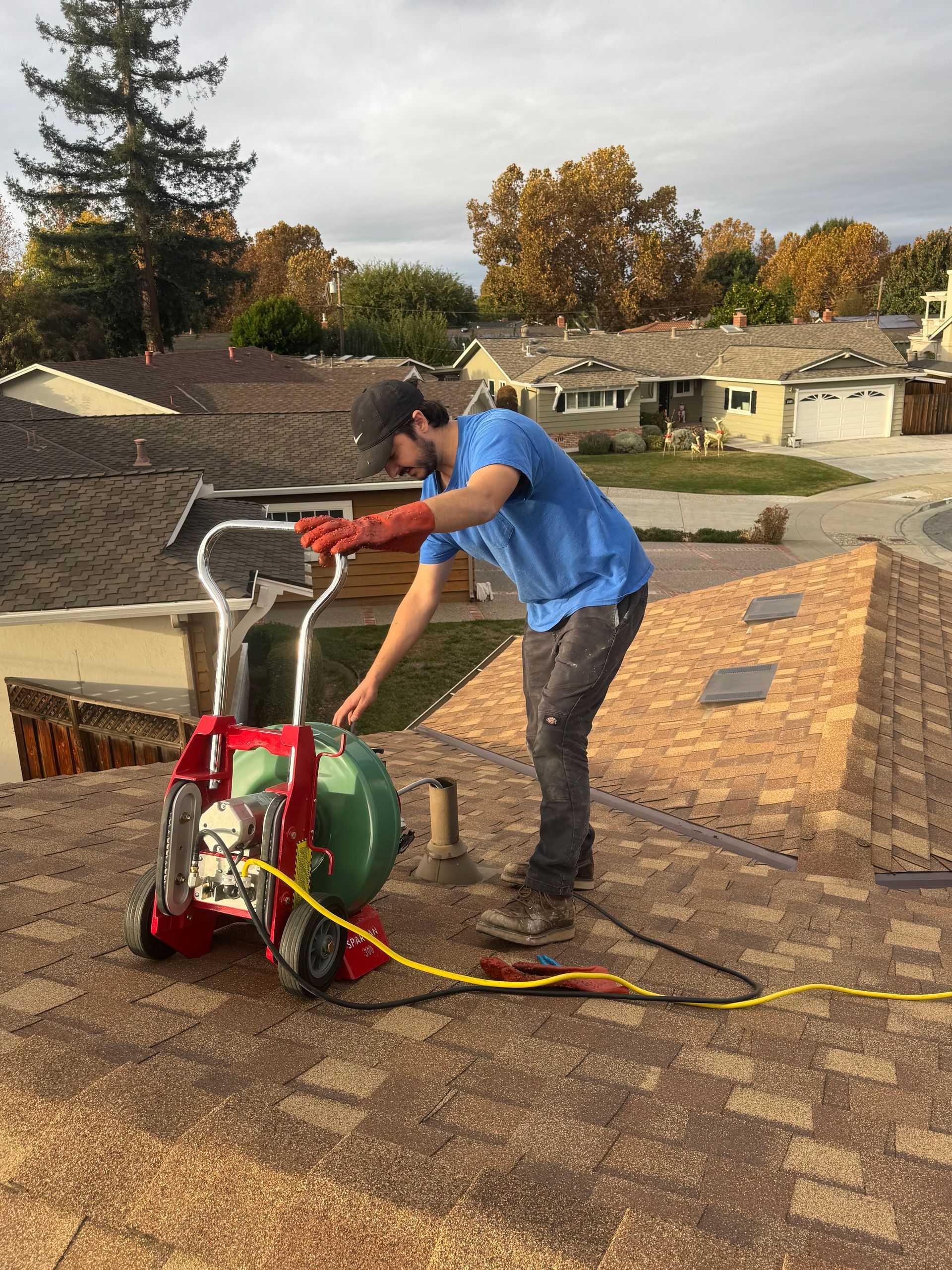 A man is working on a roof with a machine.