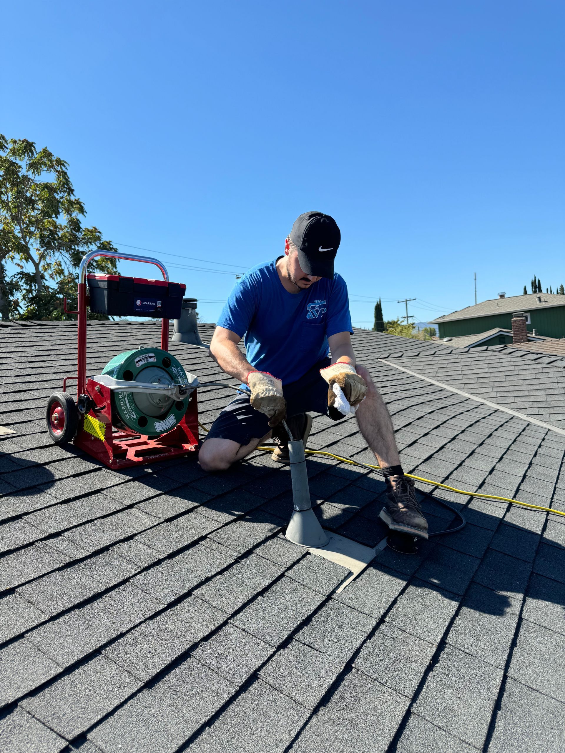 A man is kneeling on the roof of a building.