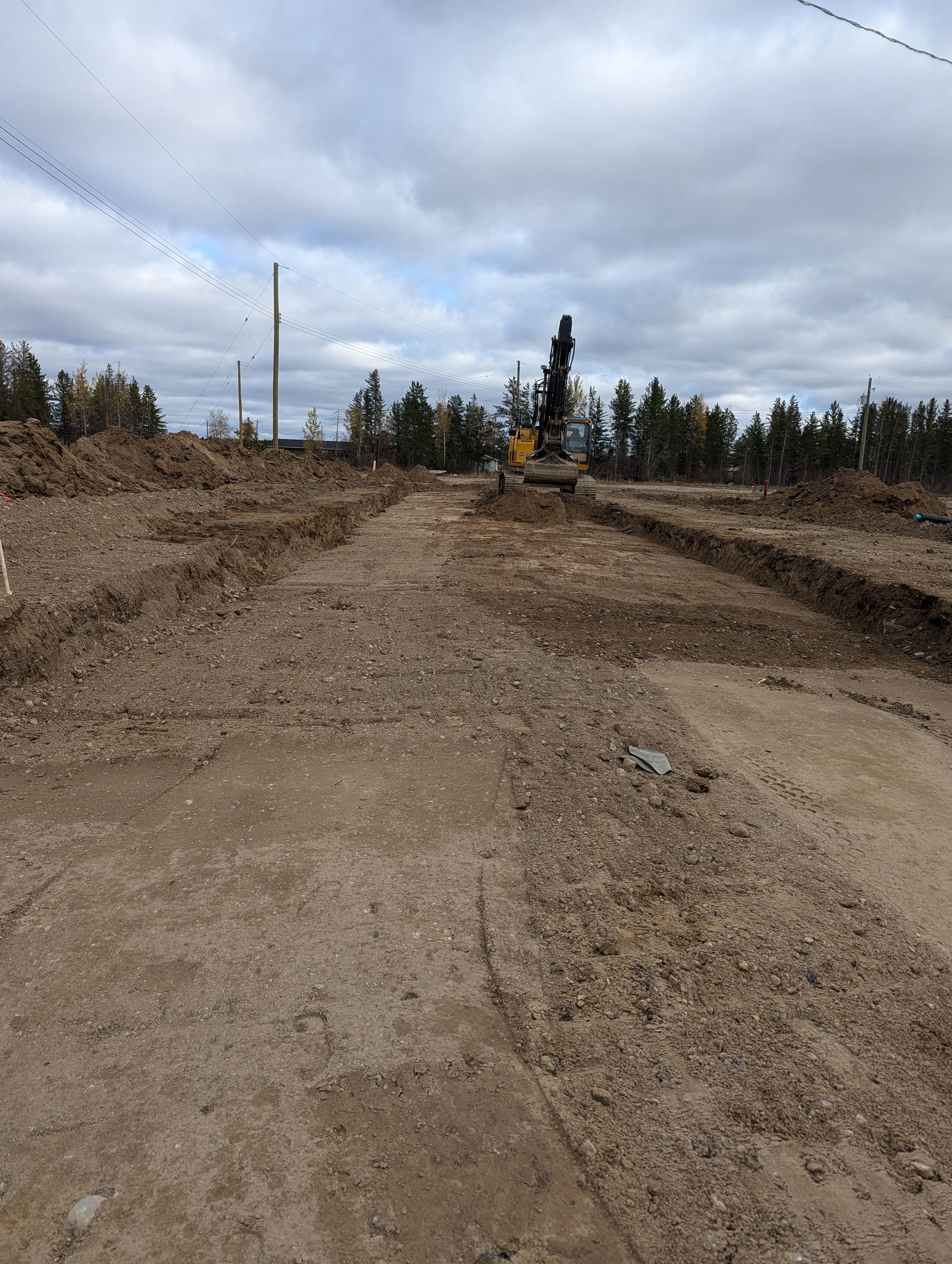 A yellow tractor is parked on the side of a city street.