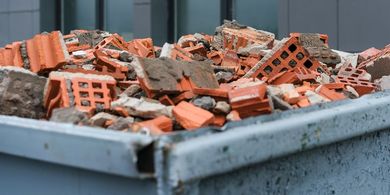 Pile of broken bricks in a metal container, likely construction debris.