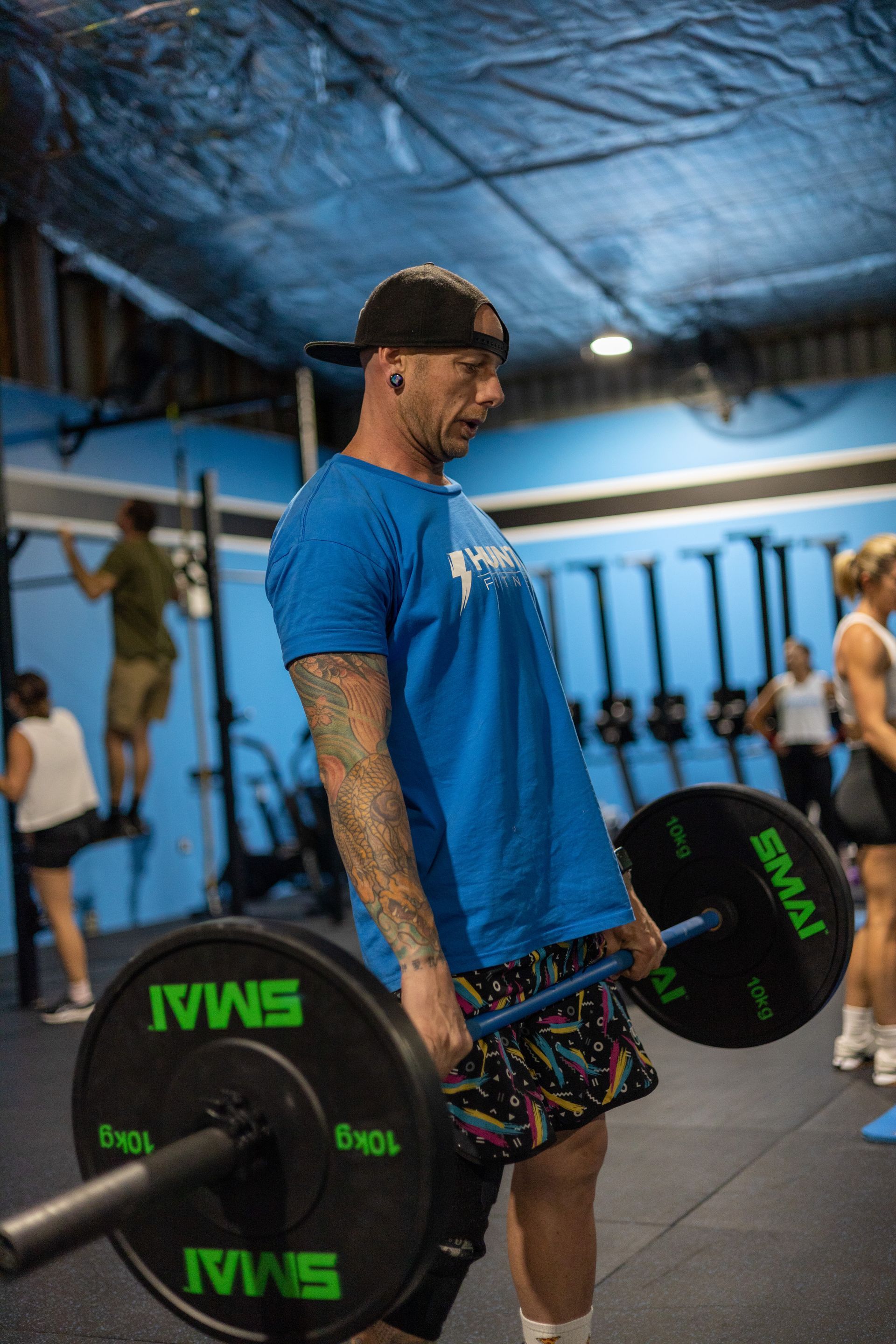 Man holding a bar with weights — Functional, Strength And Conditioning Gym in Gold Coast, QLD