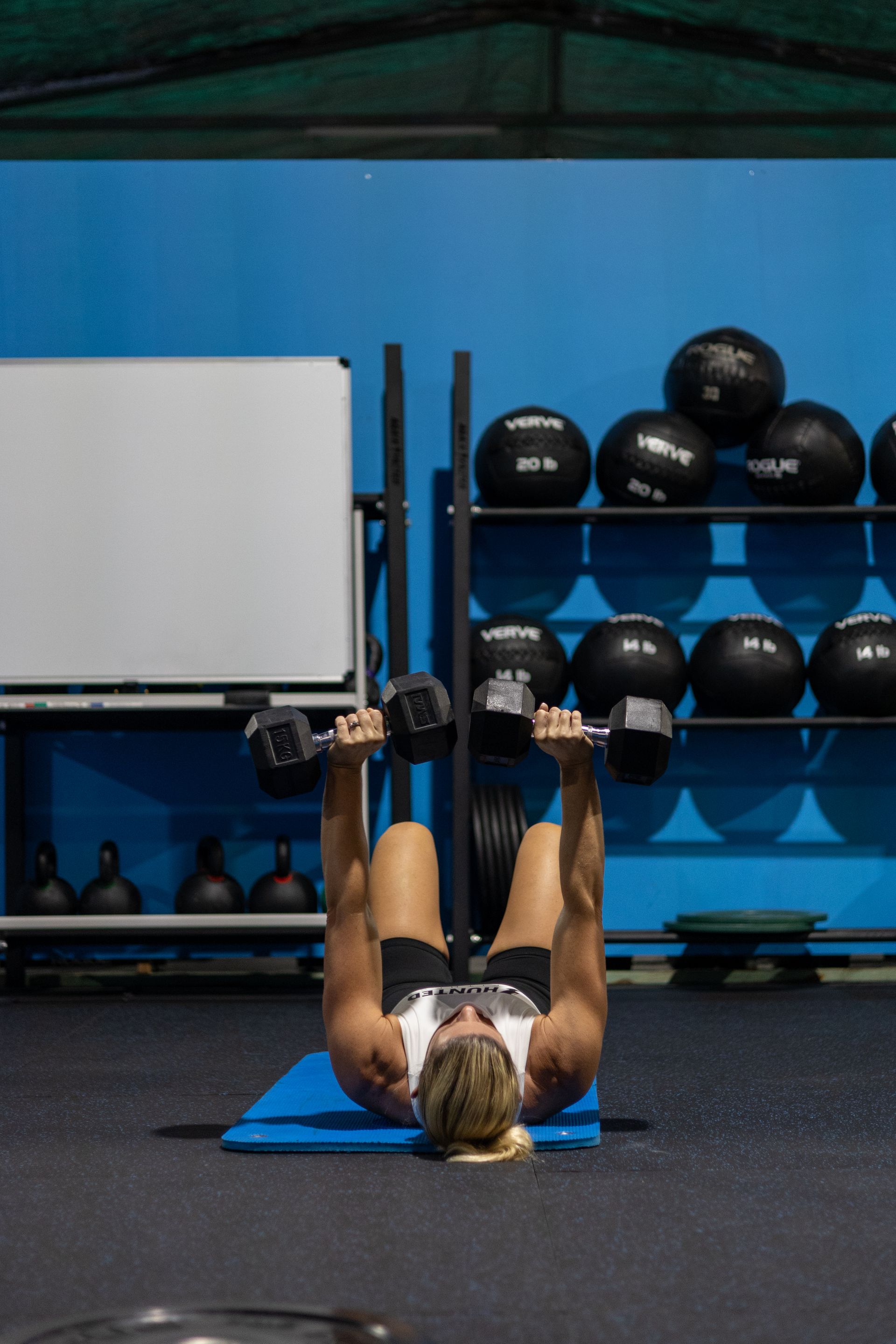 Man doing floor and dumbbell exercise — Functional, Strength And Conditioning Gym in Gold Coast, QLD