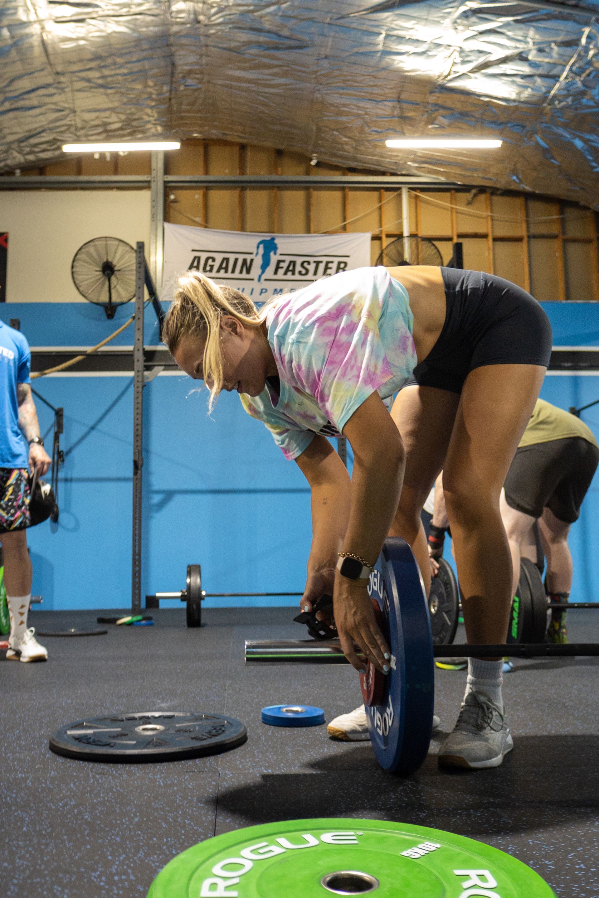 Woman changing weights — Functional, Strength And Conditioning Gym in Gold Coast, QLD