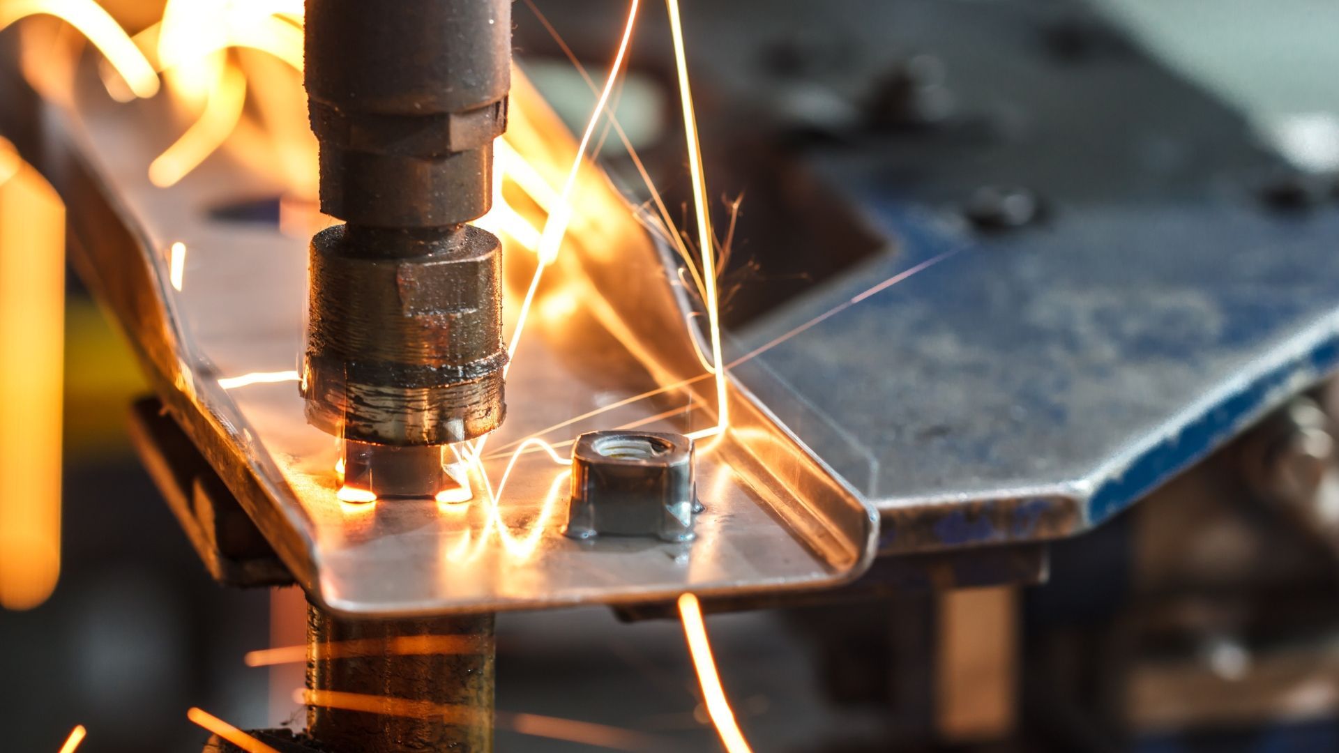 A machine is cutting a piece of metal with sparks coming out of it.