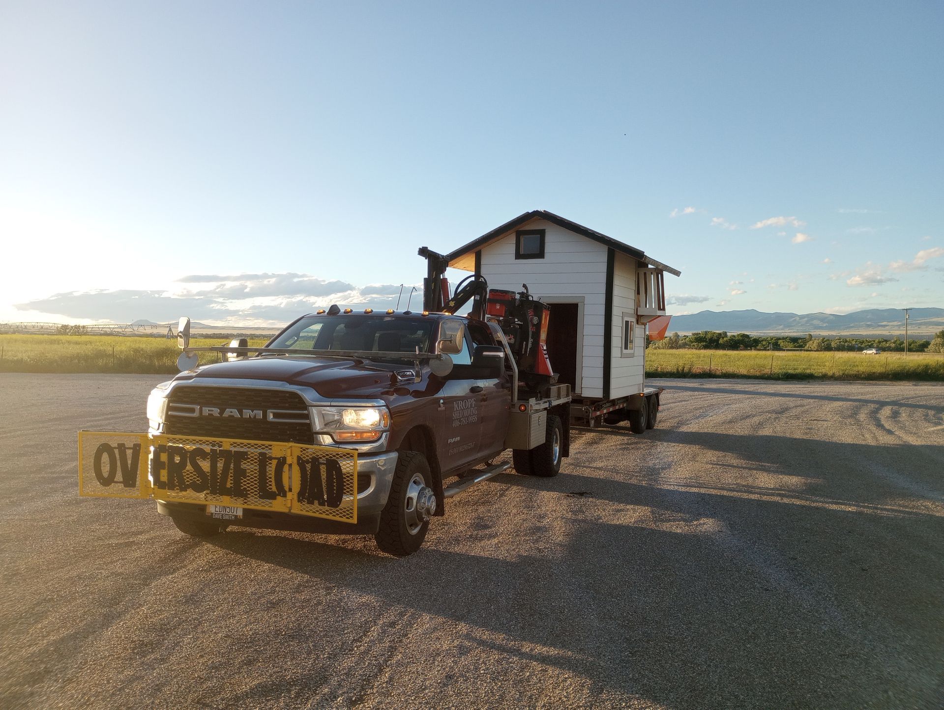 A truck is towing a small house on a trailer.