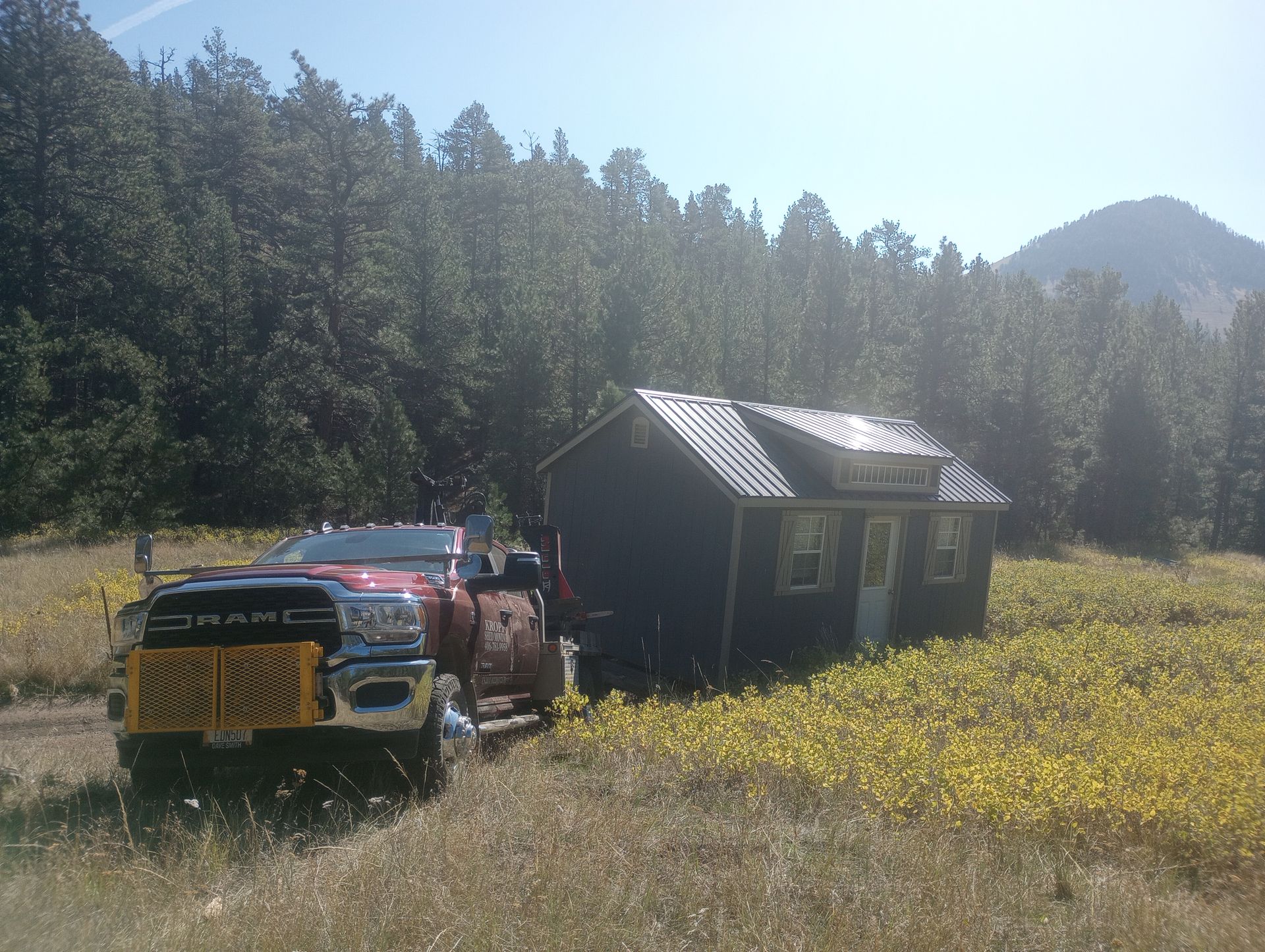 A dodge truck is parked in front of a small house