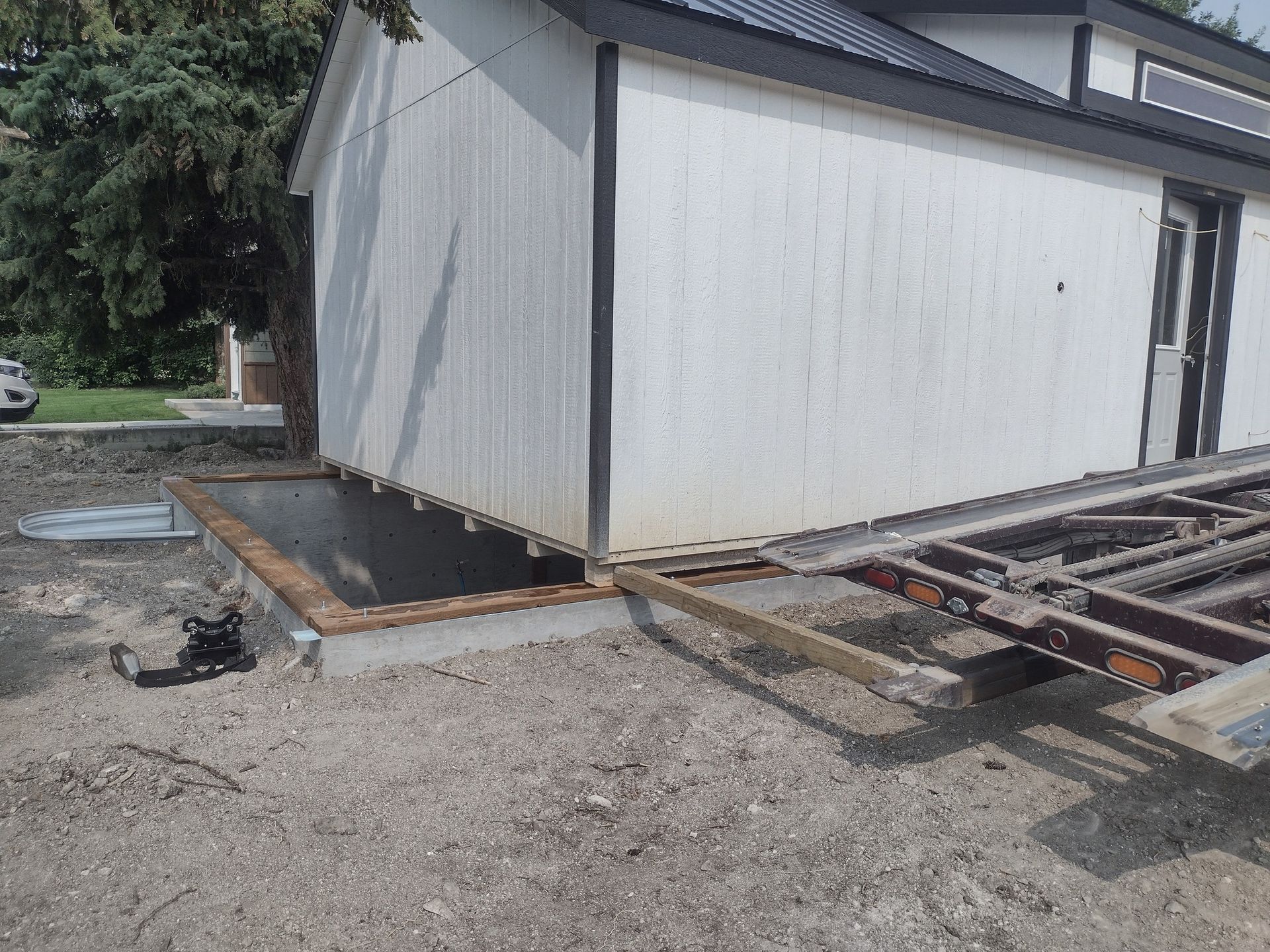 A white house with a trailer parked in front of it