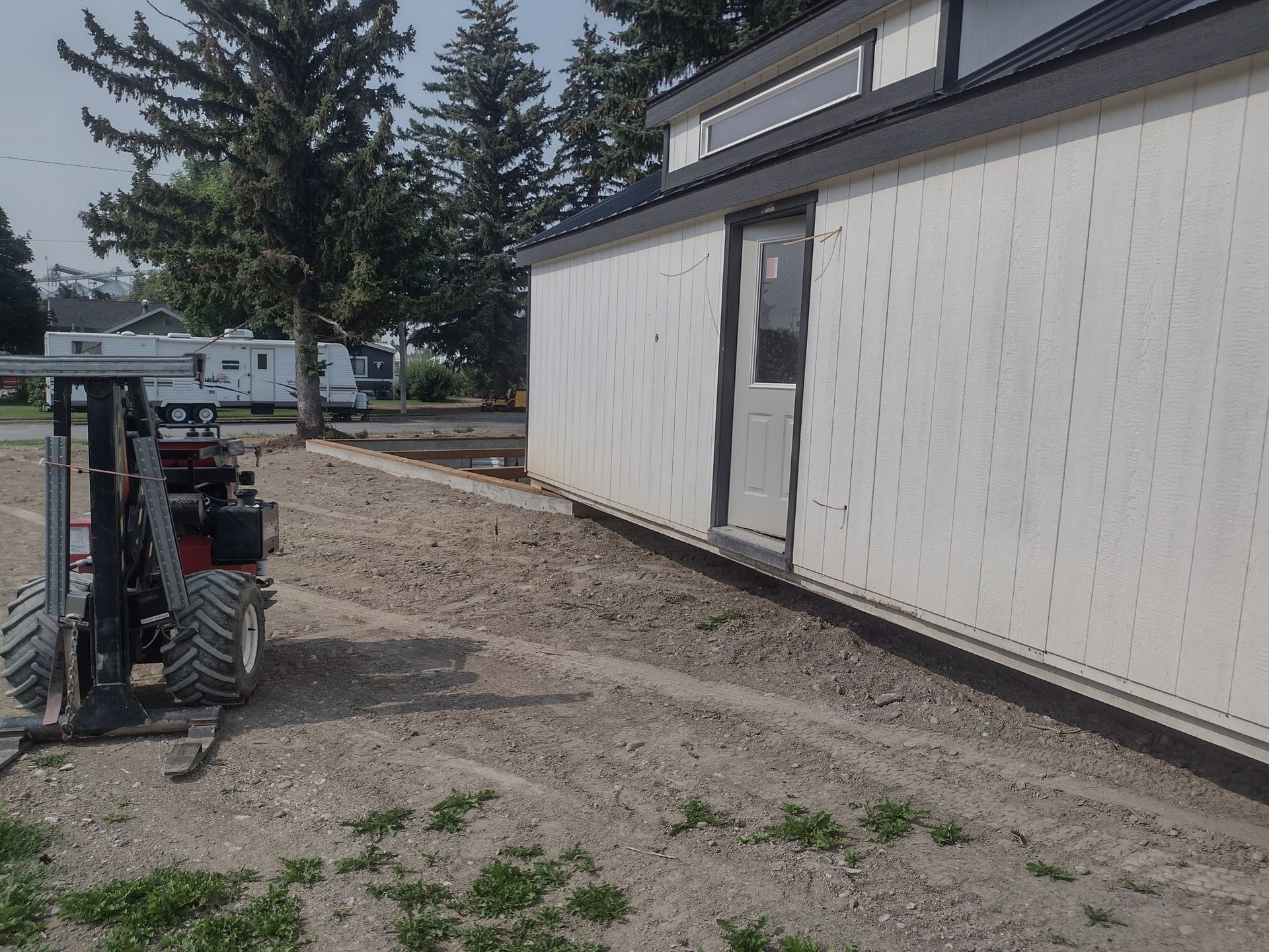 A forklift is parked in front of a white building