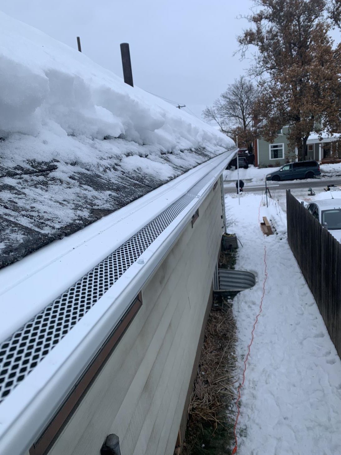 A close-up view of a roof gutter system installed along the edge of a house.