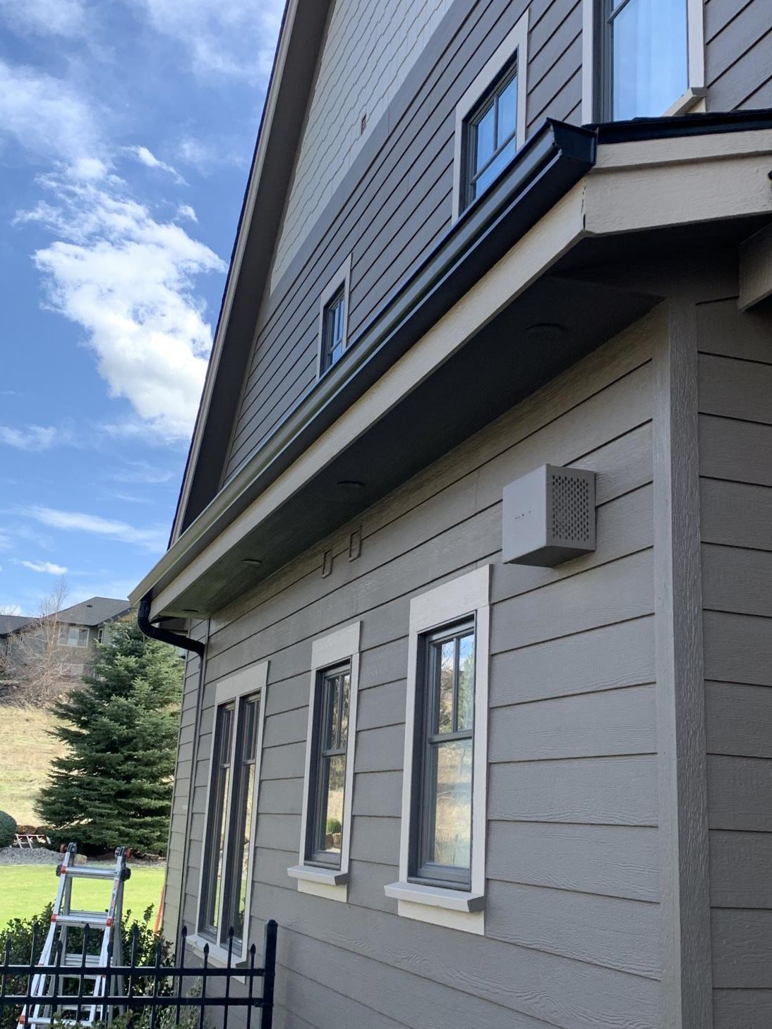 A skilled worker is installing a rain gutter system on the roof of a house.