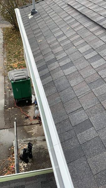 A close-up view of a roof gutter system installed along the edge of a house.
