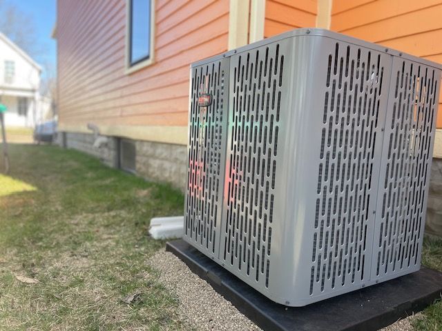 An air conditioner is sitting outside of a house.