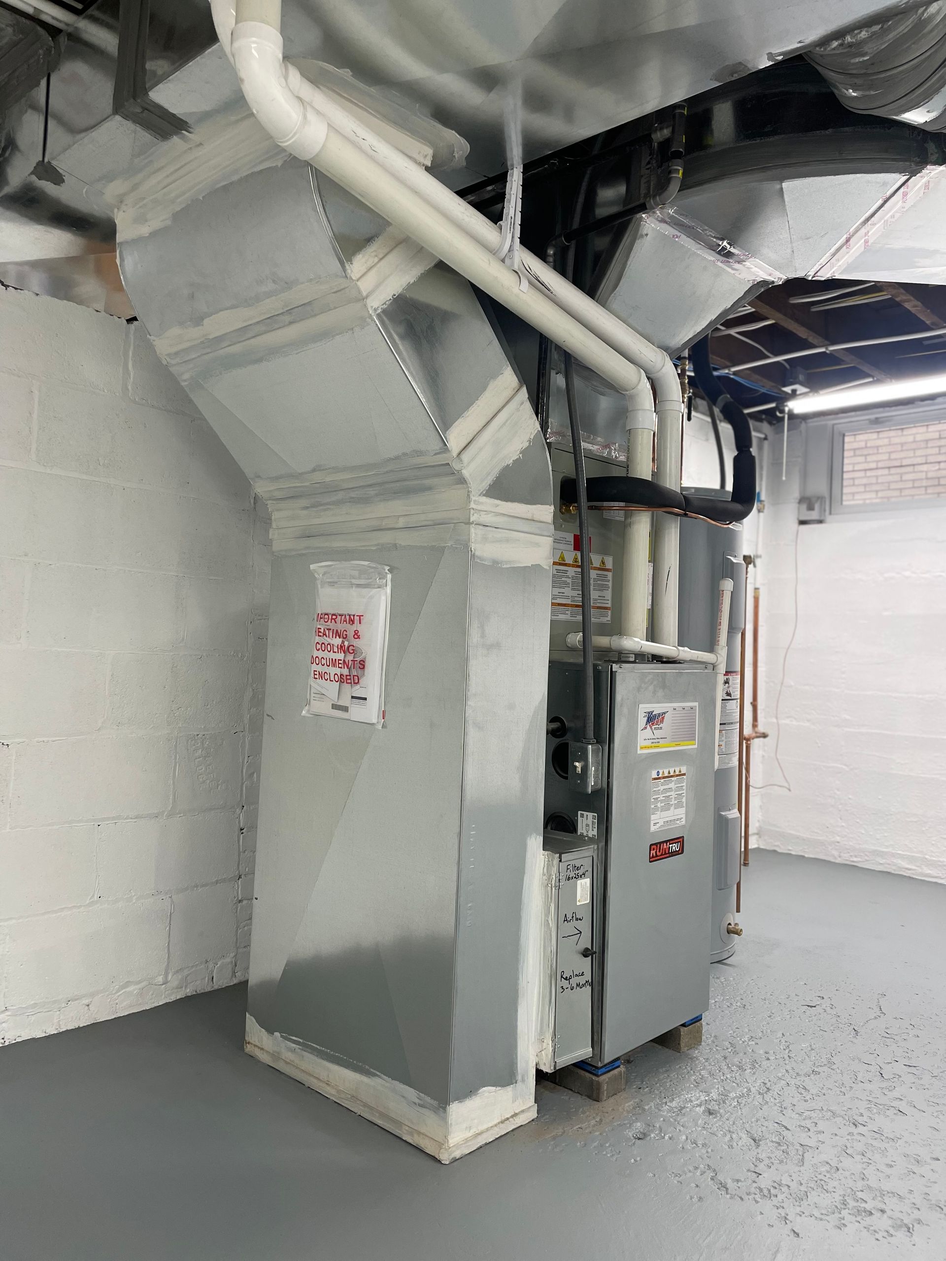 A room with a heater and pipes coming out of it.