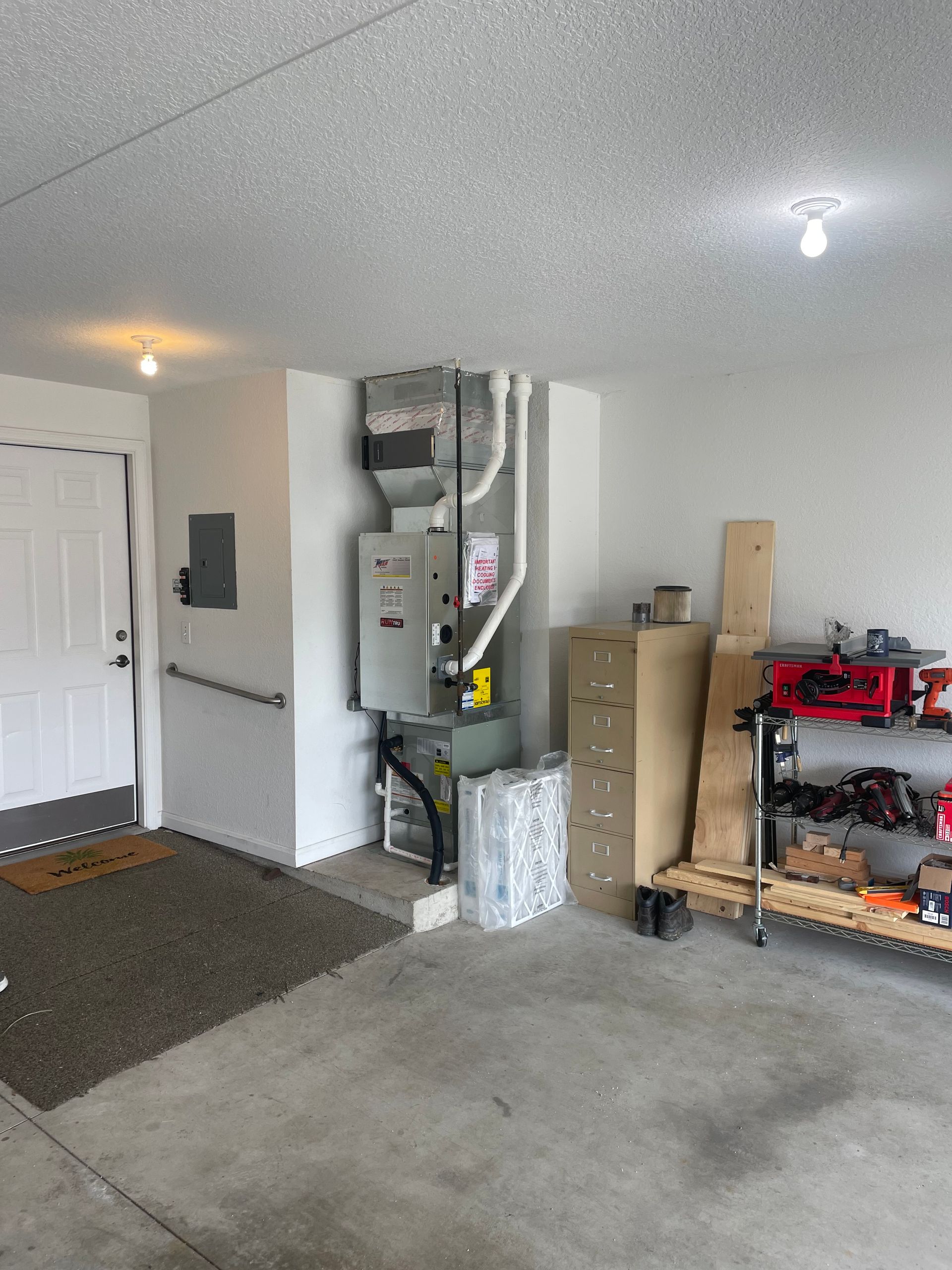 A garage with a heater on the wall and a door.