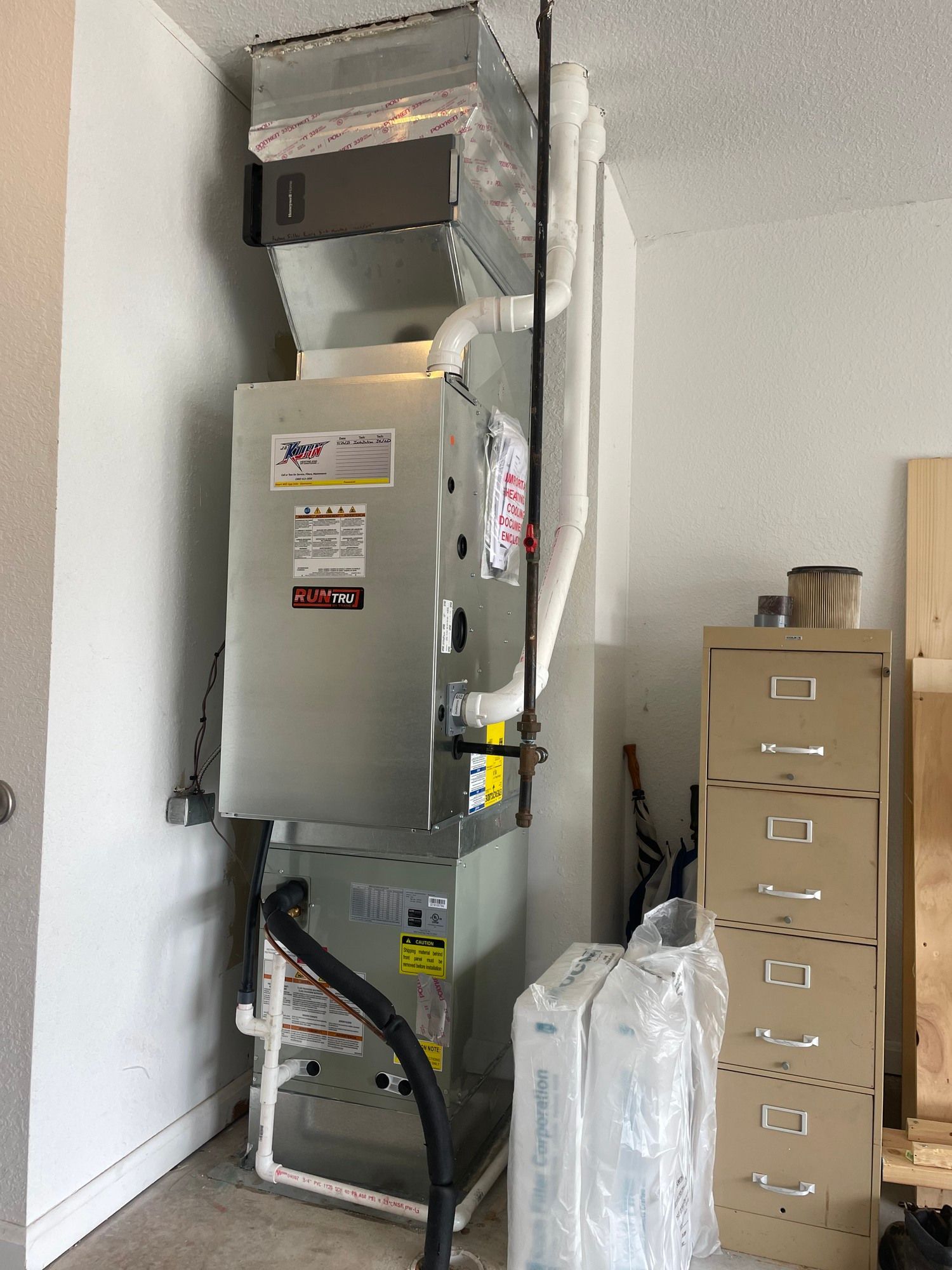 A furnace is sitting in a room next to a vacuum cleaner.