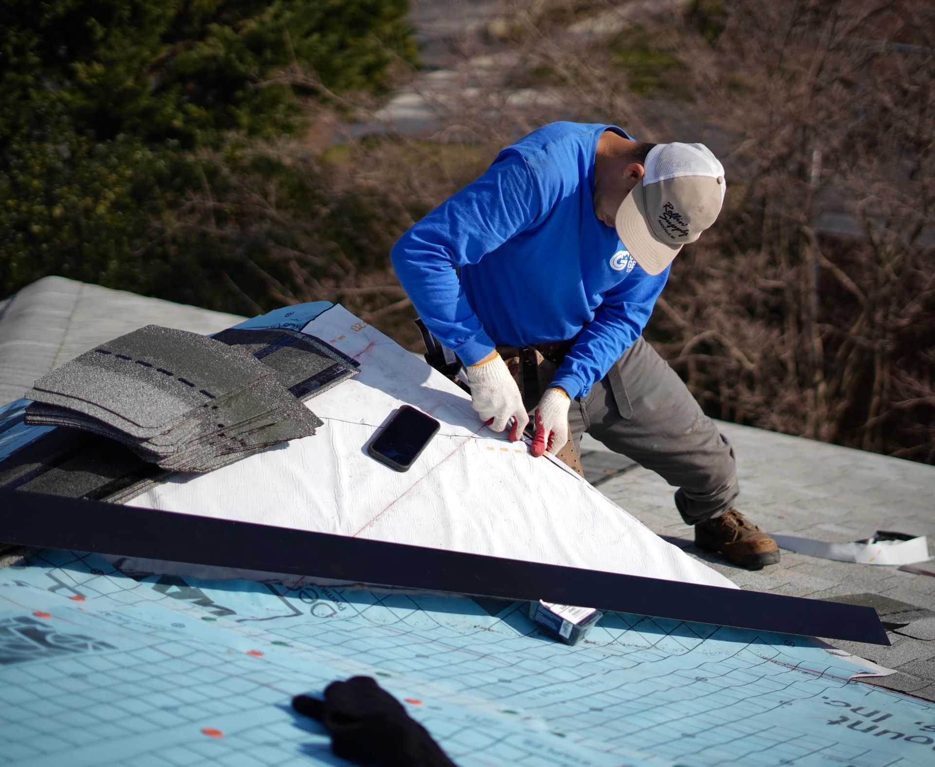 A man in a blue shirt is working on a roof