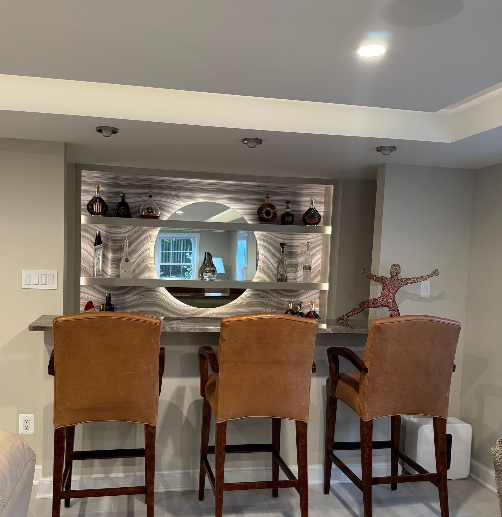 Three chairs are sitting in front of the custom bar