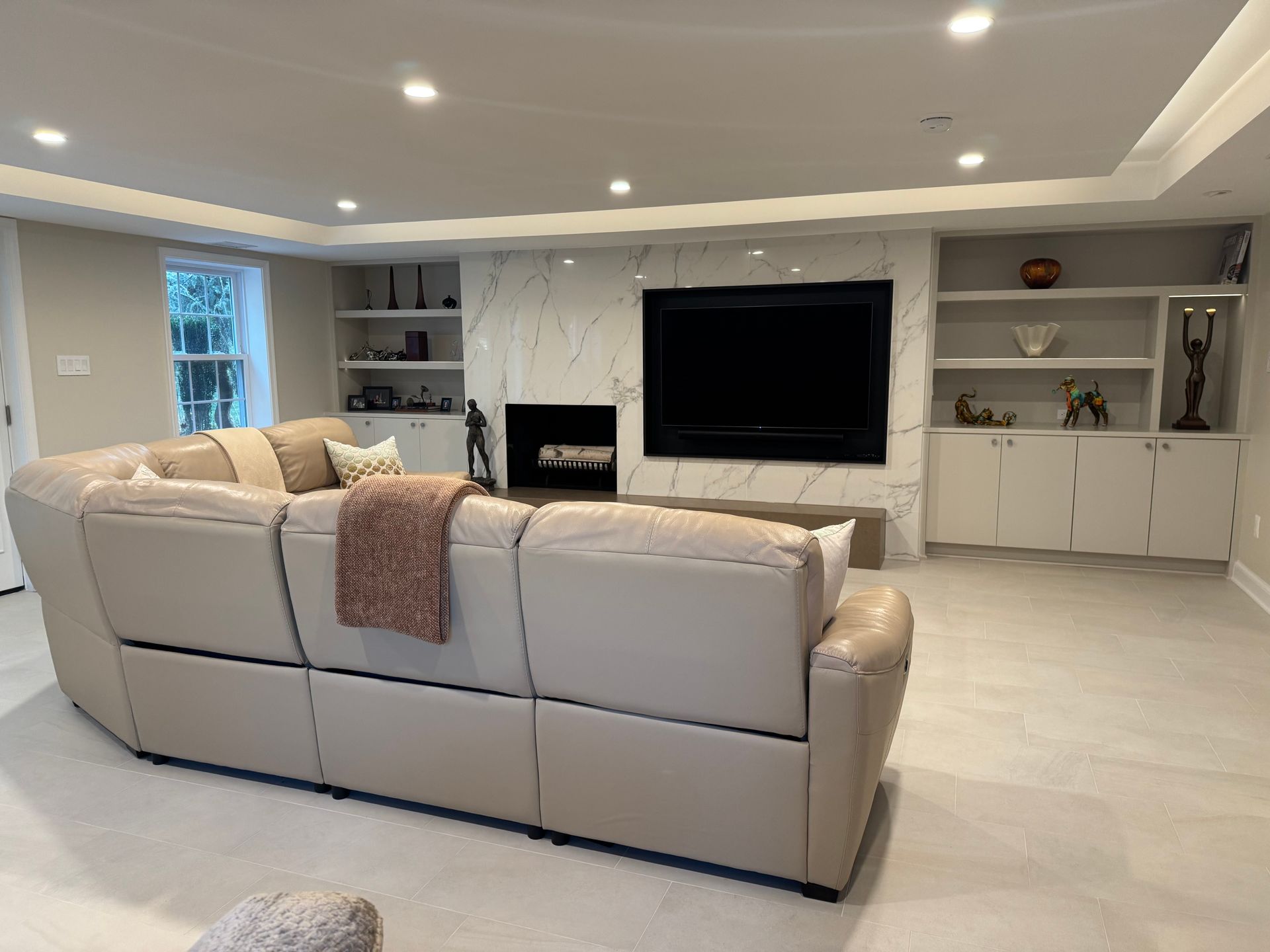 A living room with a couch , television and fireplace.