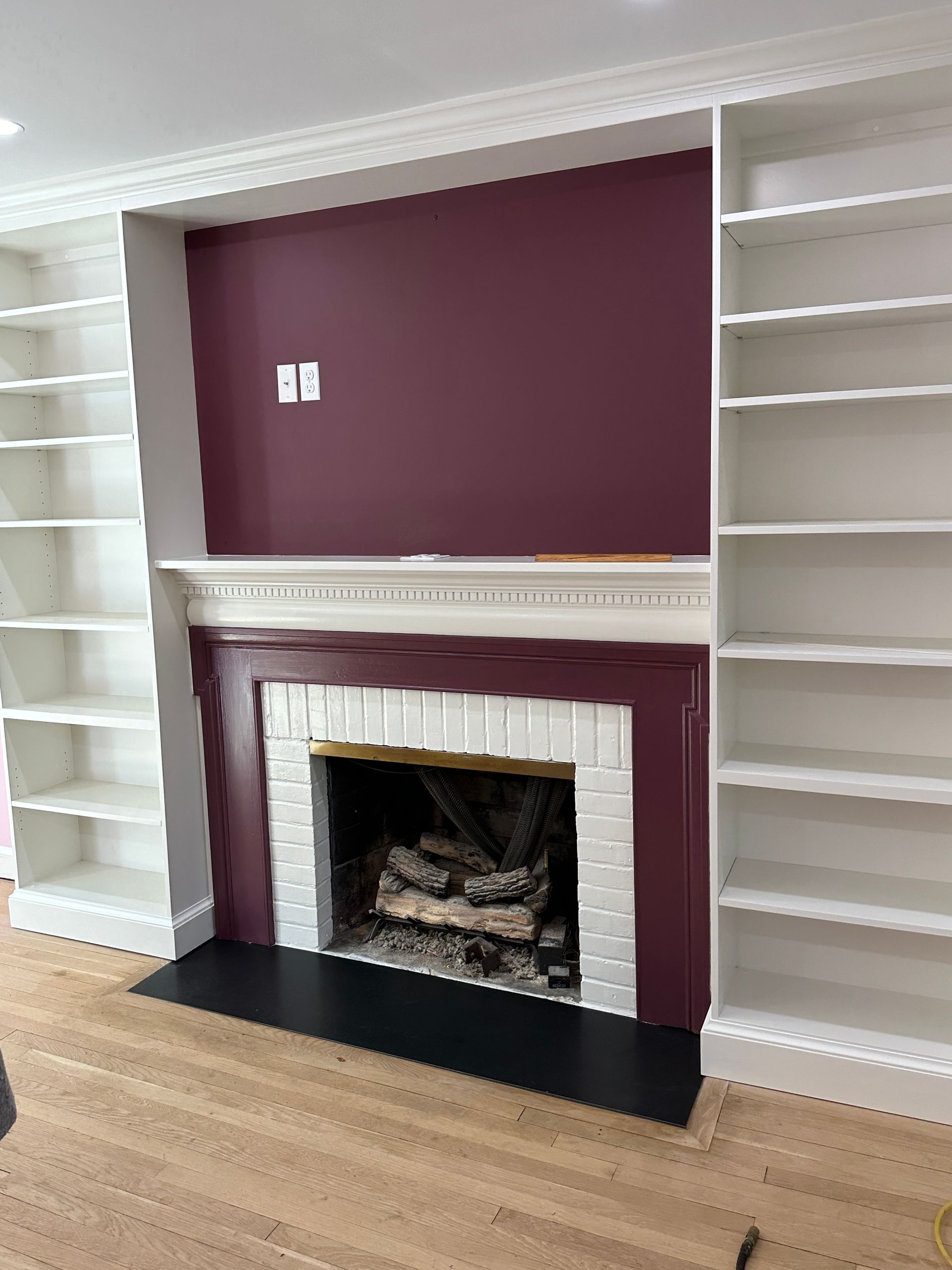 A living room with a fireplace and lots of shelves