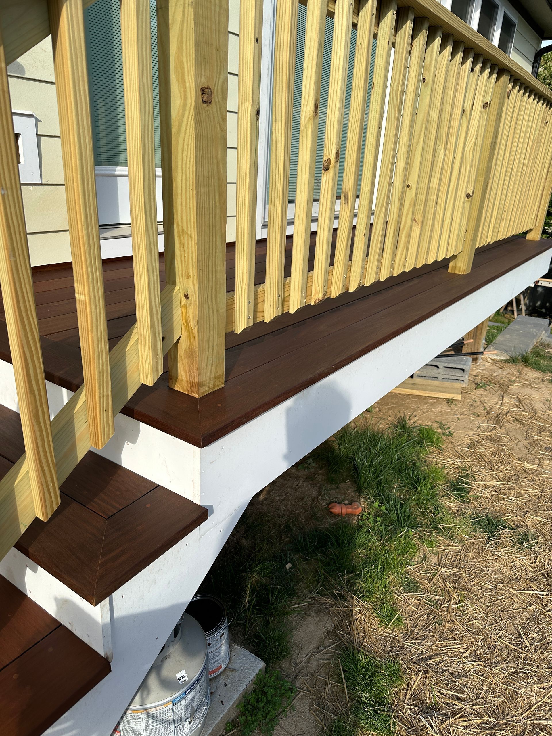 A wooden deck with stairs and a wooden railing