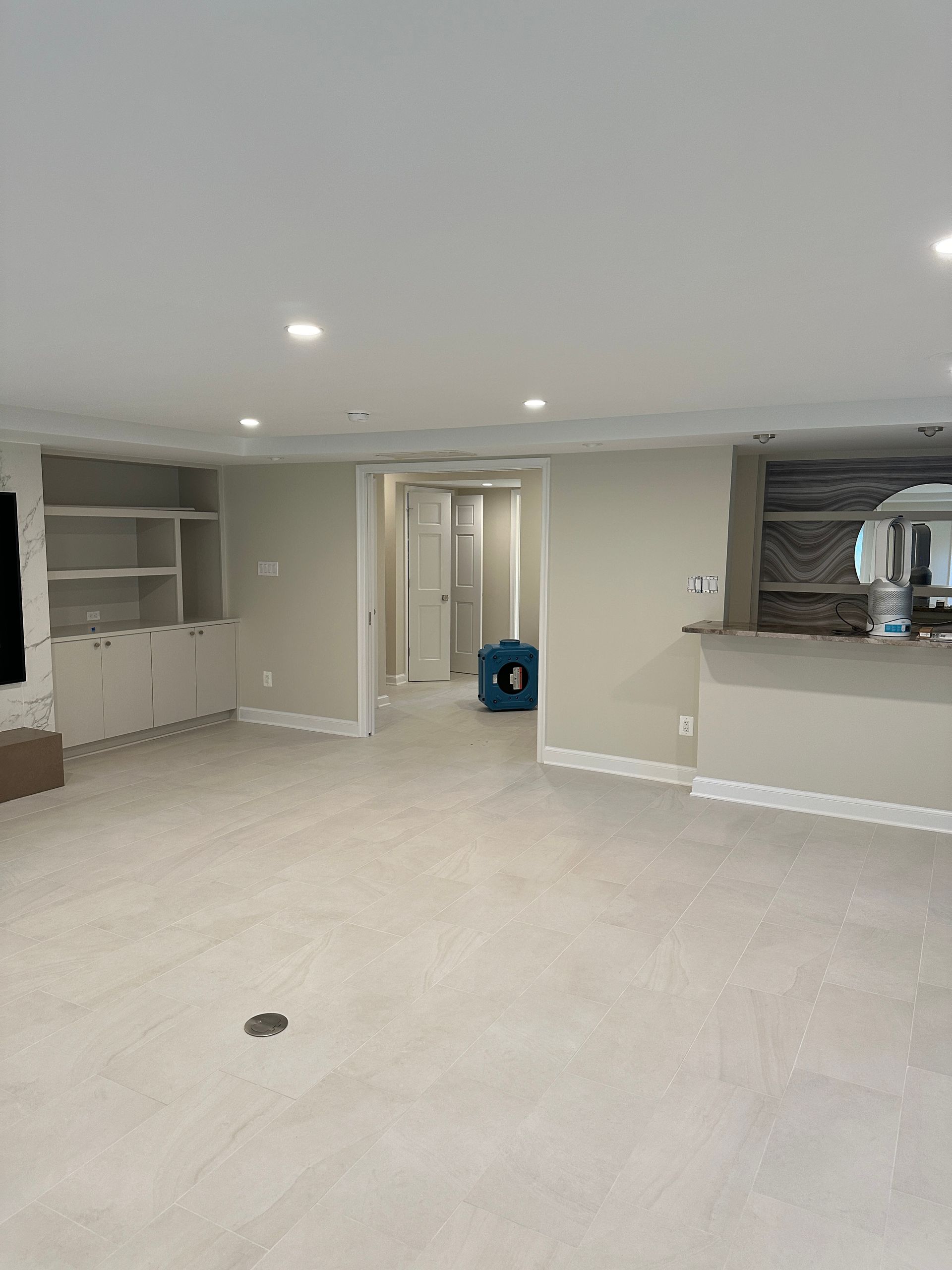 A large empty room with white tile floors and white walls.