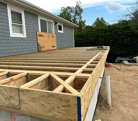 Framework for the addition is being built in front of a house.