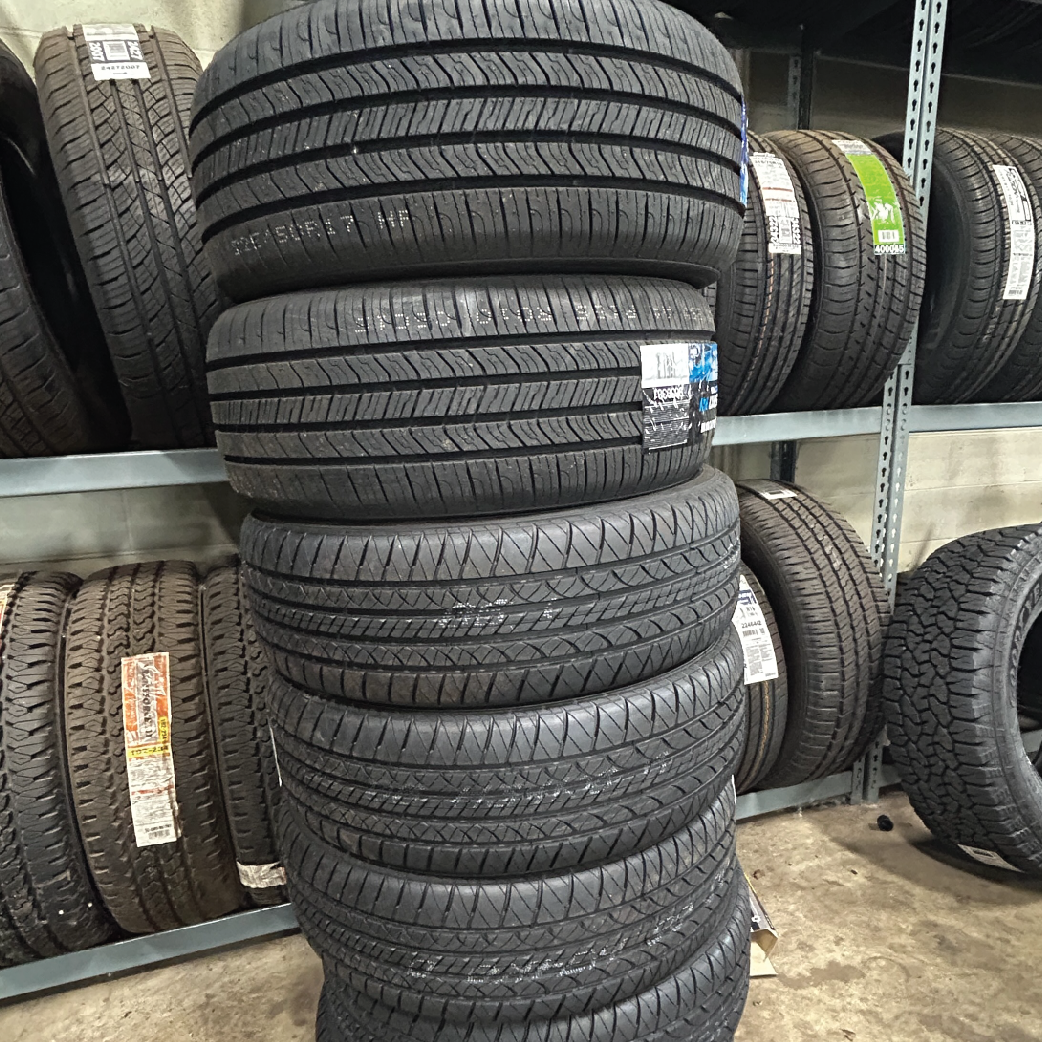 Stack of used car tires inside a tire shop.