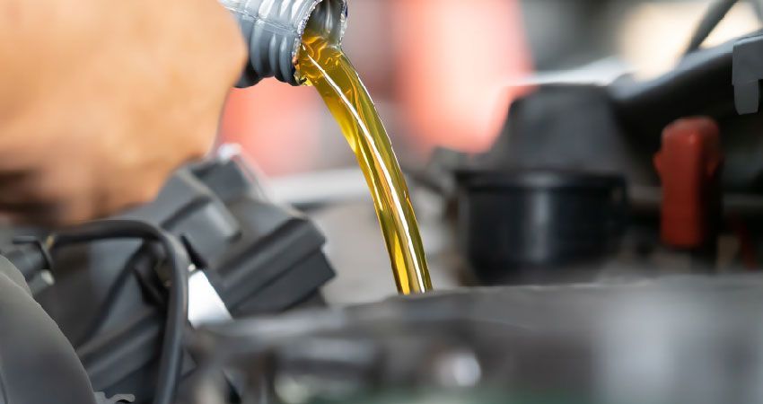 Mechanic putting oil into an engine