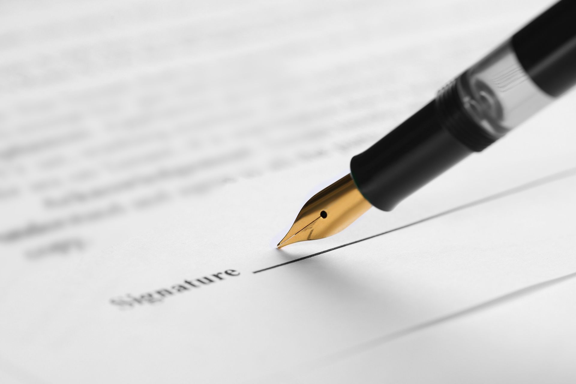 A fountain pen is writing the word signature on a piece of paper.