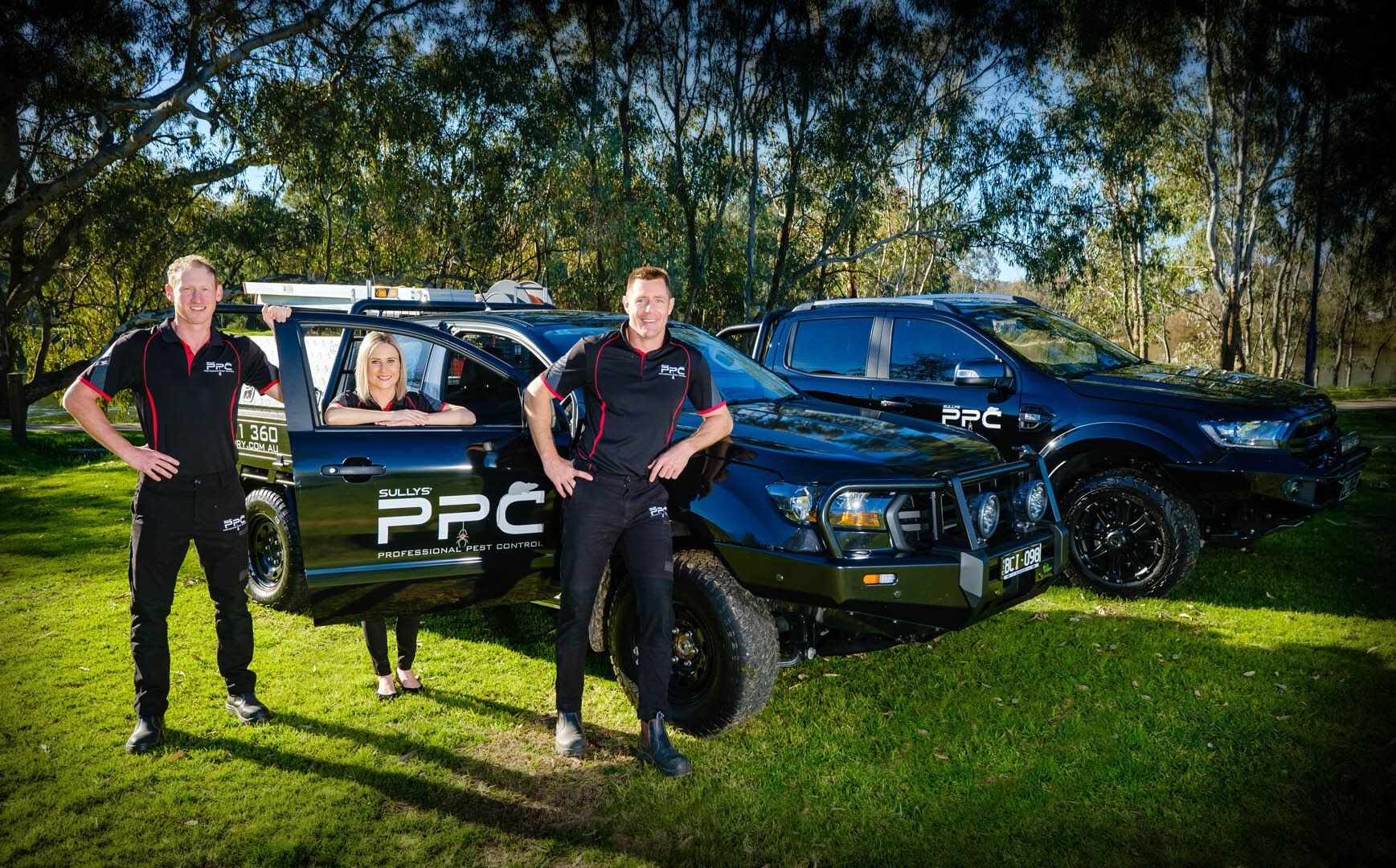 Staff standing with vehicles — Professional Pest Control In Thurgoona NSW