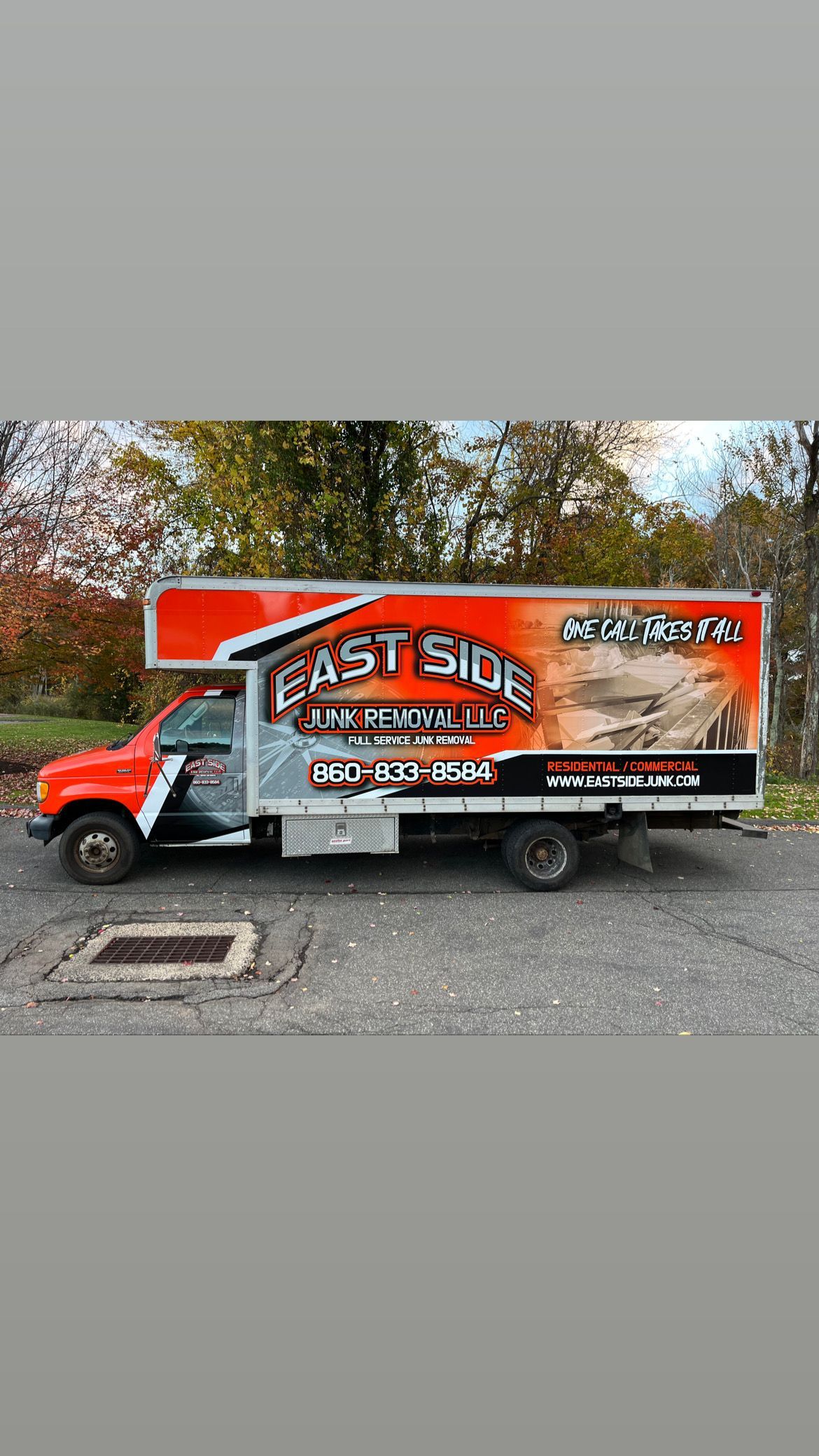 A red and white truck is parked in a parking lot.