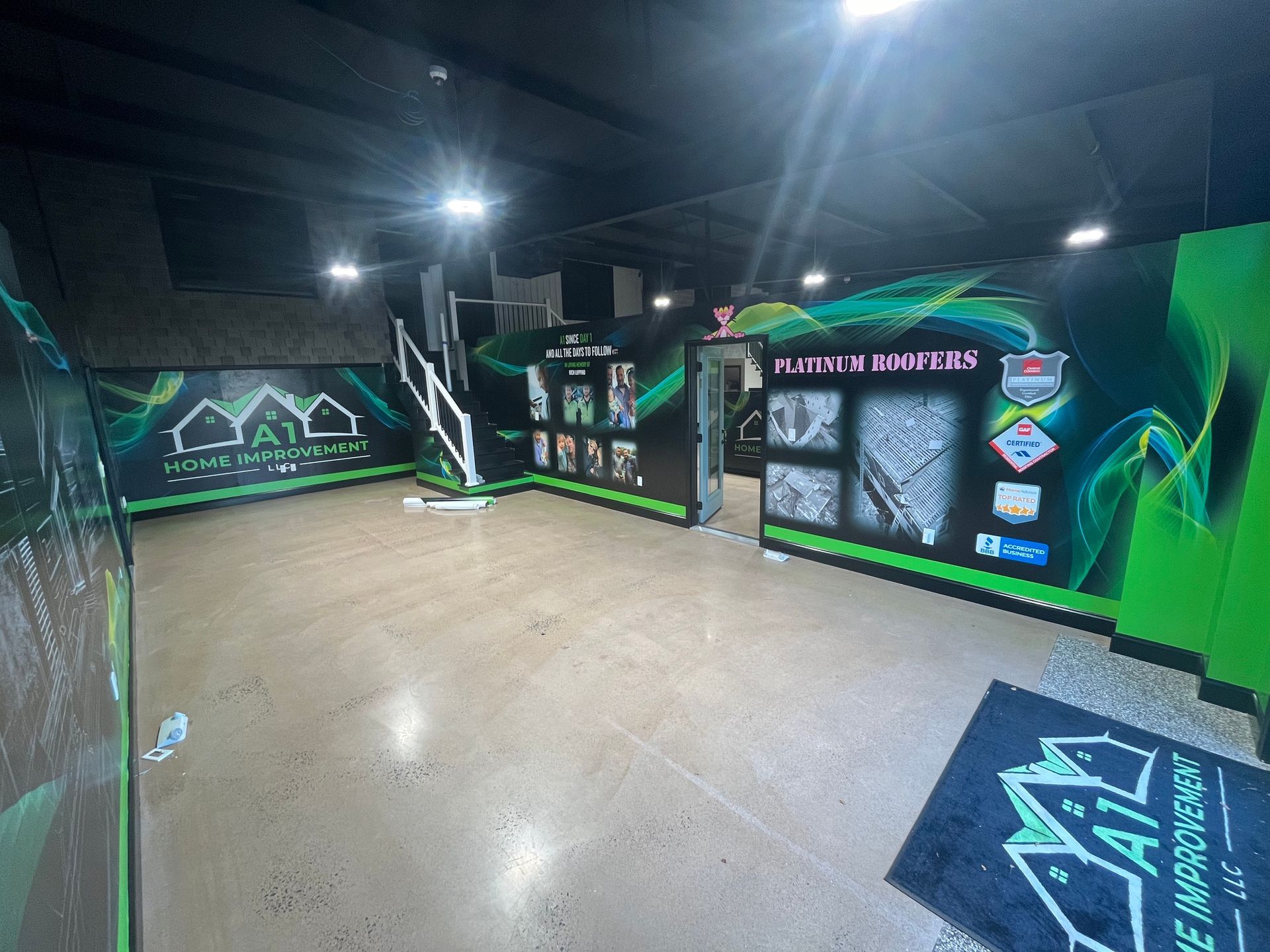 A large empty room with green walls and stairs.