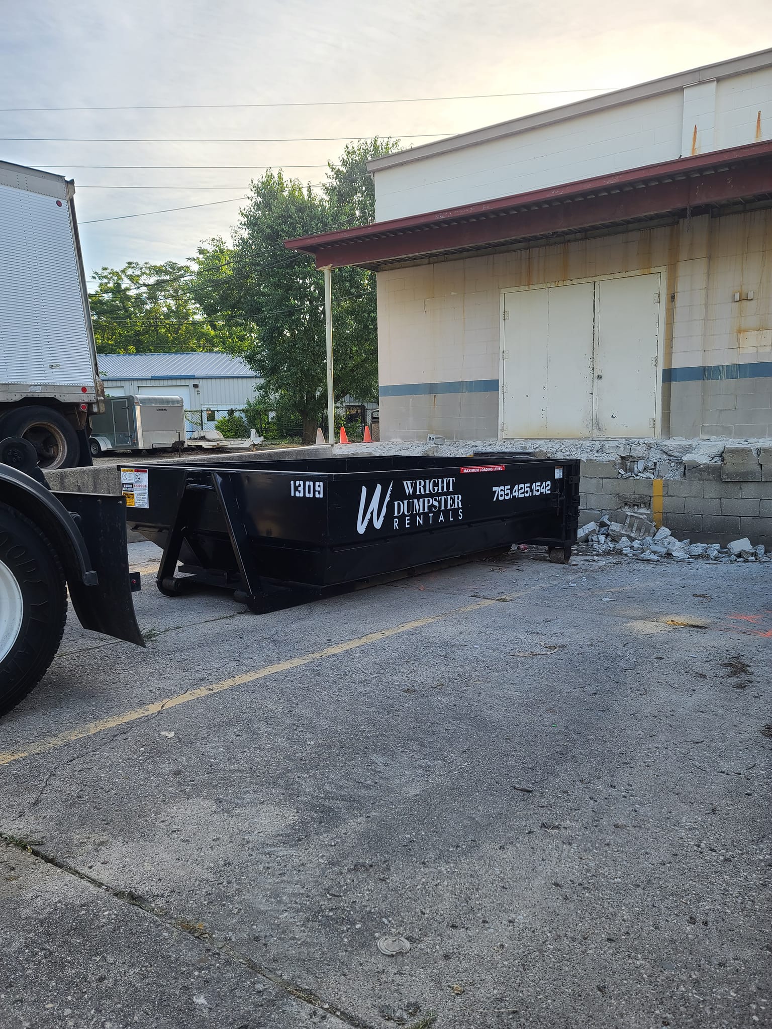small black dumpster at back of building, best dumpster rental services, madison county in, wright dumpster rentals