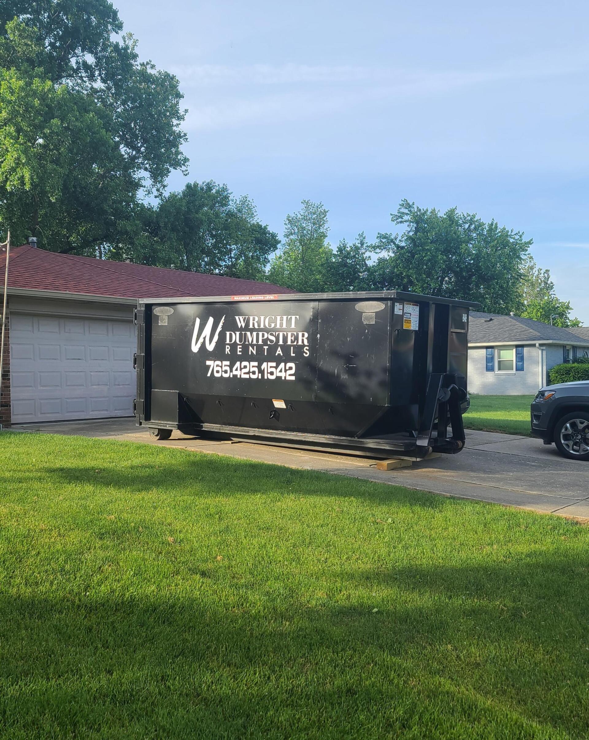 large black dumpster in front of garage, best dumpster rental company near me, madison county IN, wright dumpster rentals
