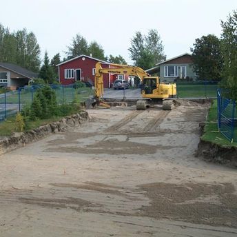 pelle mécanique jaune qui creuse chemin