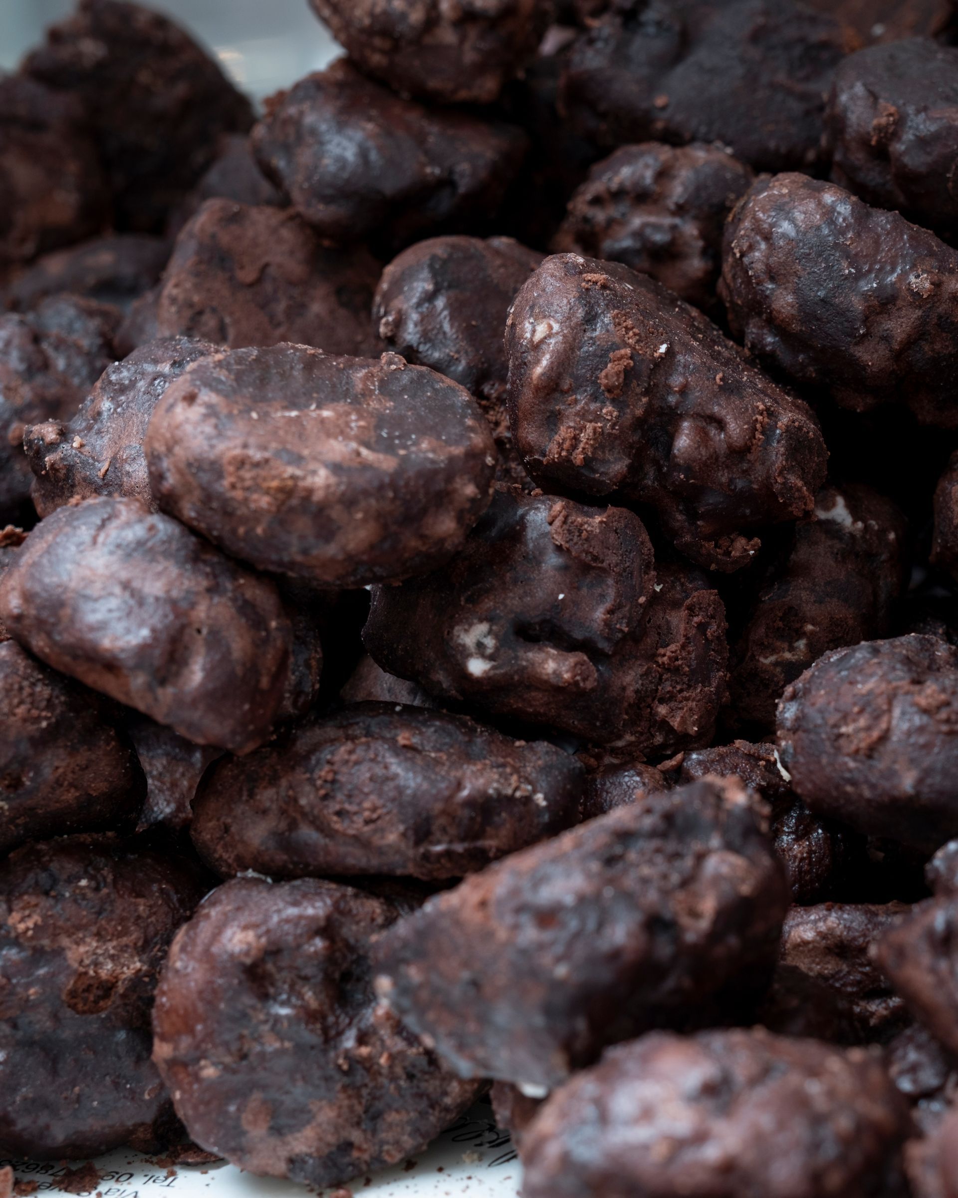 Mucchio di biscotti ricoperti di cioccolato, marrone scuro con superfici ruvide e ruvide.