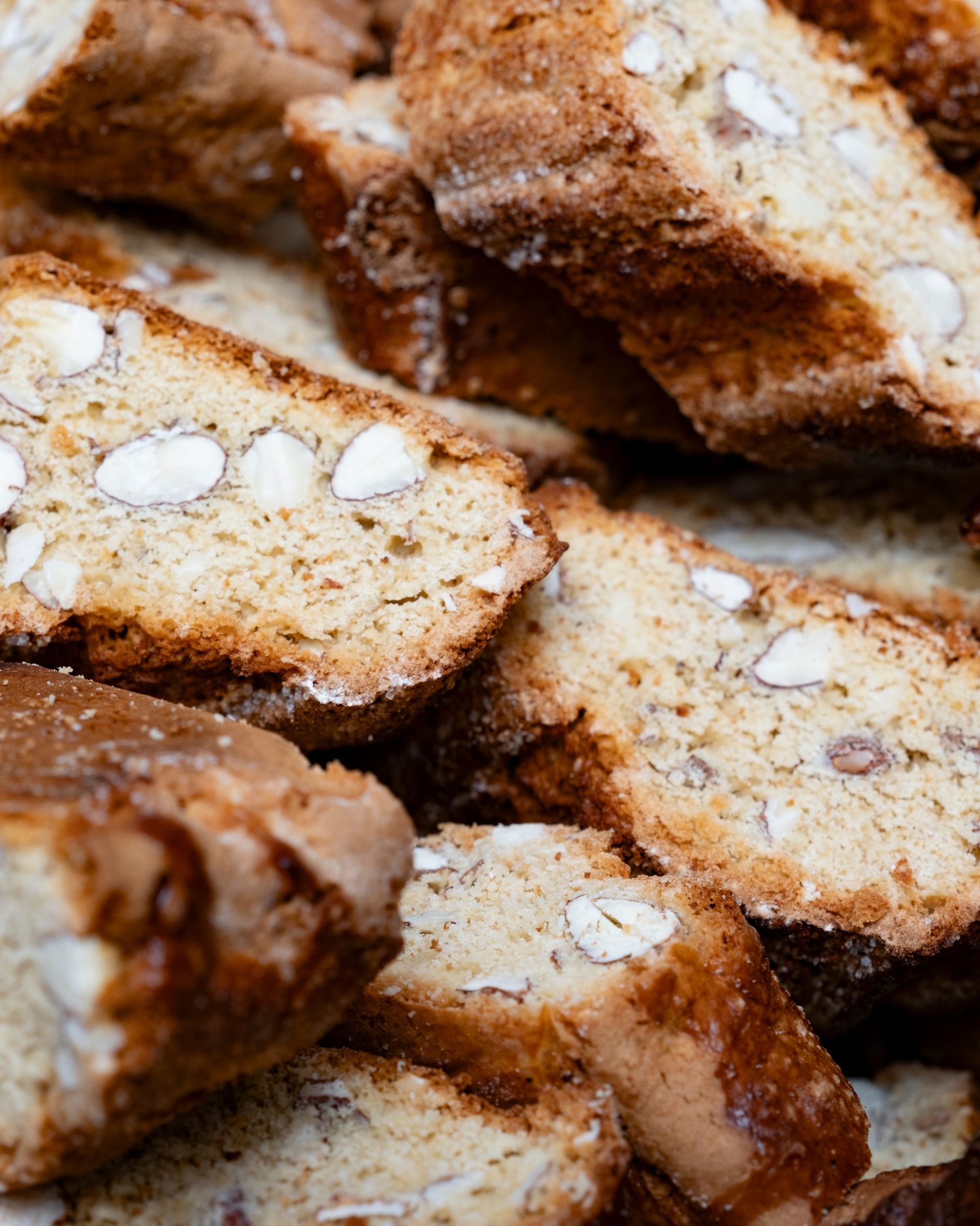 Primo piano di diverse fette di biscotti con mandorle visibili.