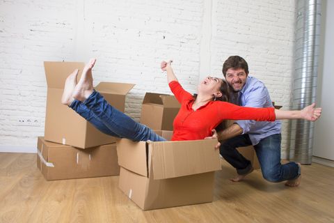 happy couple moving in new house woman playing inside box