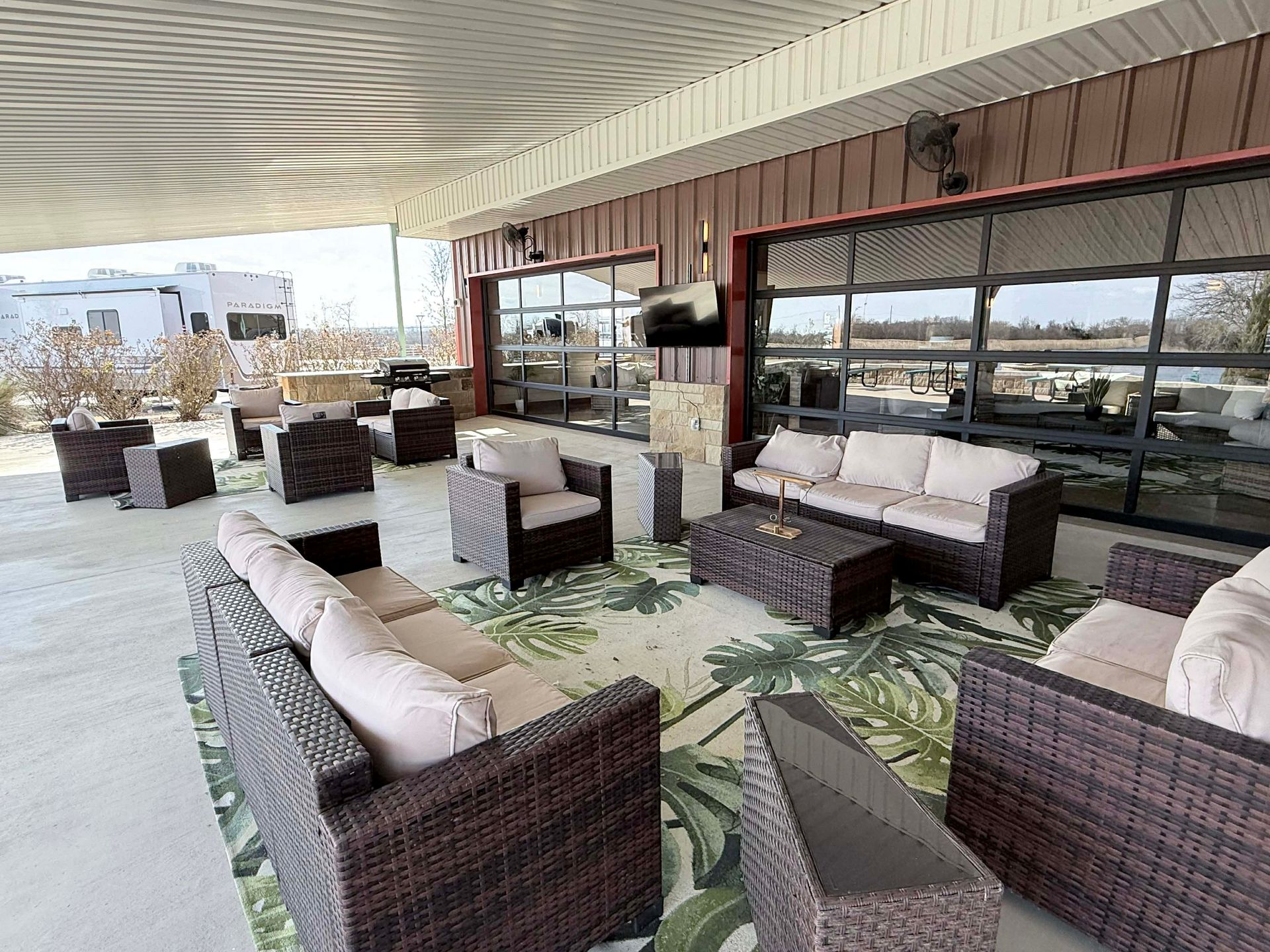 A patio with chairs and a ladder in front of a red building.